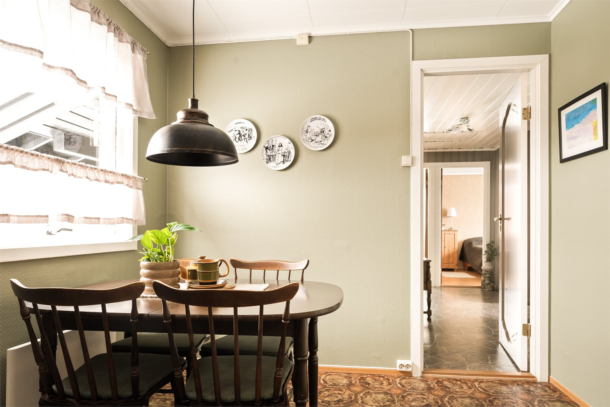 Under kjøkkenvinduet, badet i naturlig dagslys, står det koselige kjøkkenbordet – en selvsagt samlingsplass i rommet.