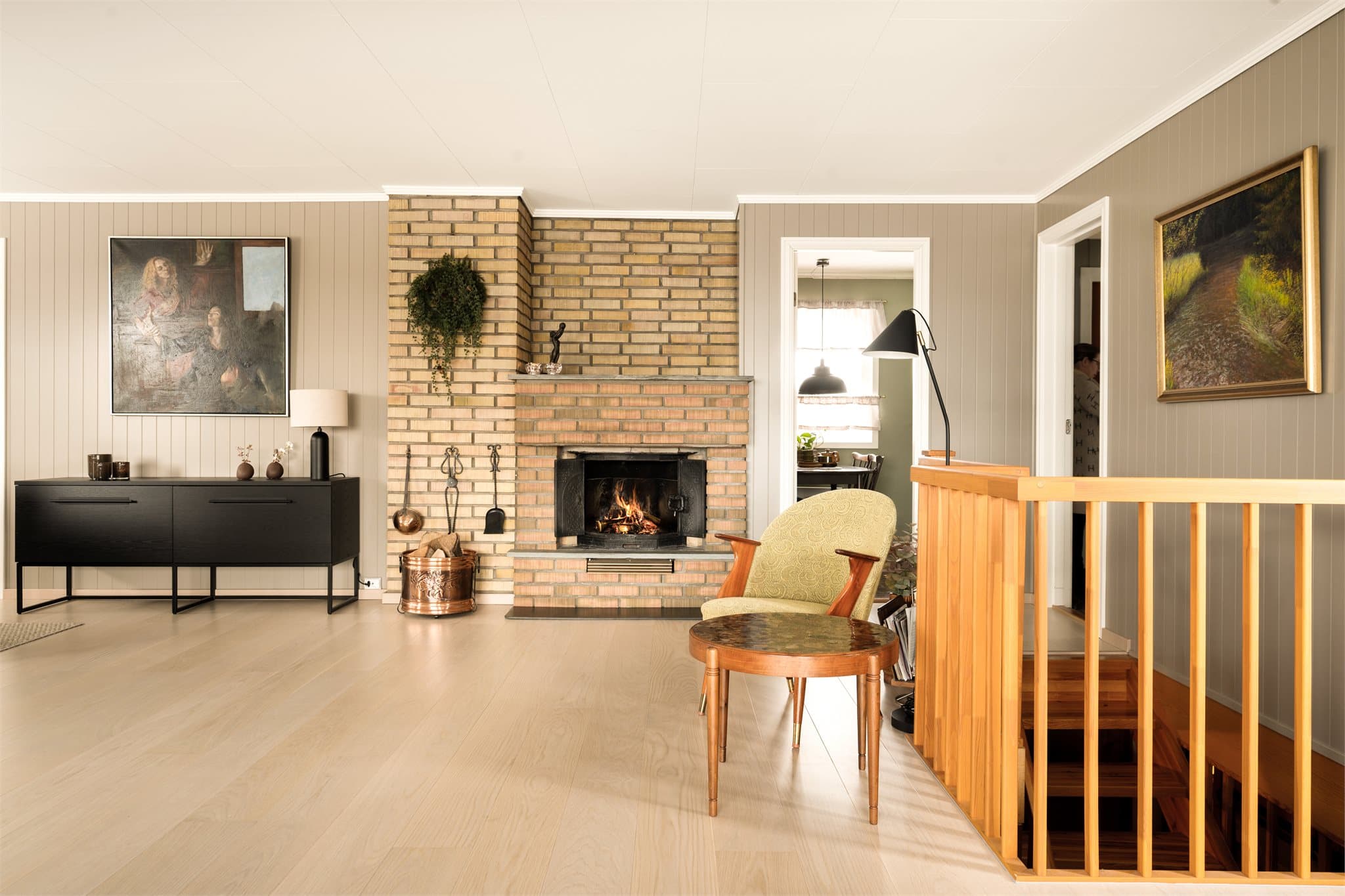 Peisen, med sine tette støpejernsdører, tilfører en ekstra dimensjon av autentisk retro. Her er det ikke flammene som spiller hovedrollen visuelt – men selve formen, materialet og den solide tilstedeværelsen.