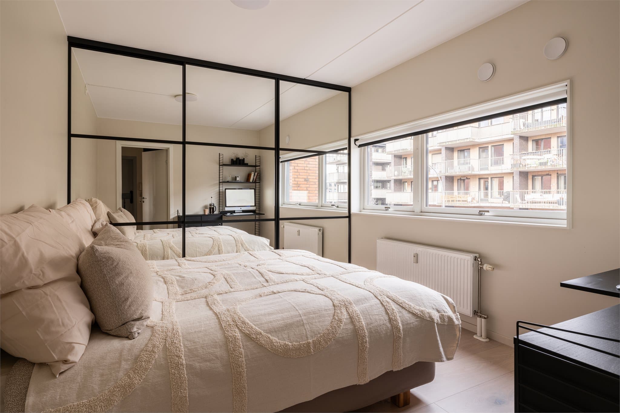 Videre kommer du til hovedsoverommet med lyse vegger, stort vindu og rikelig med garderobeplass.