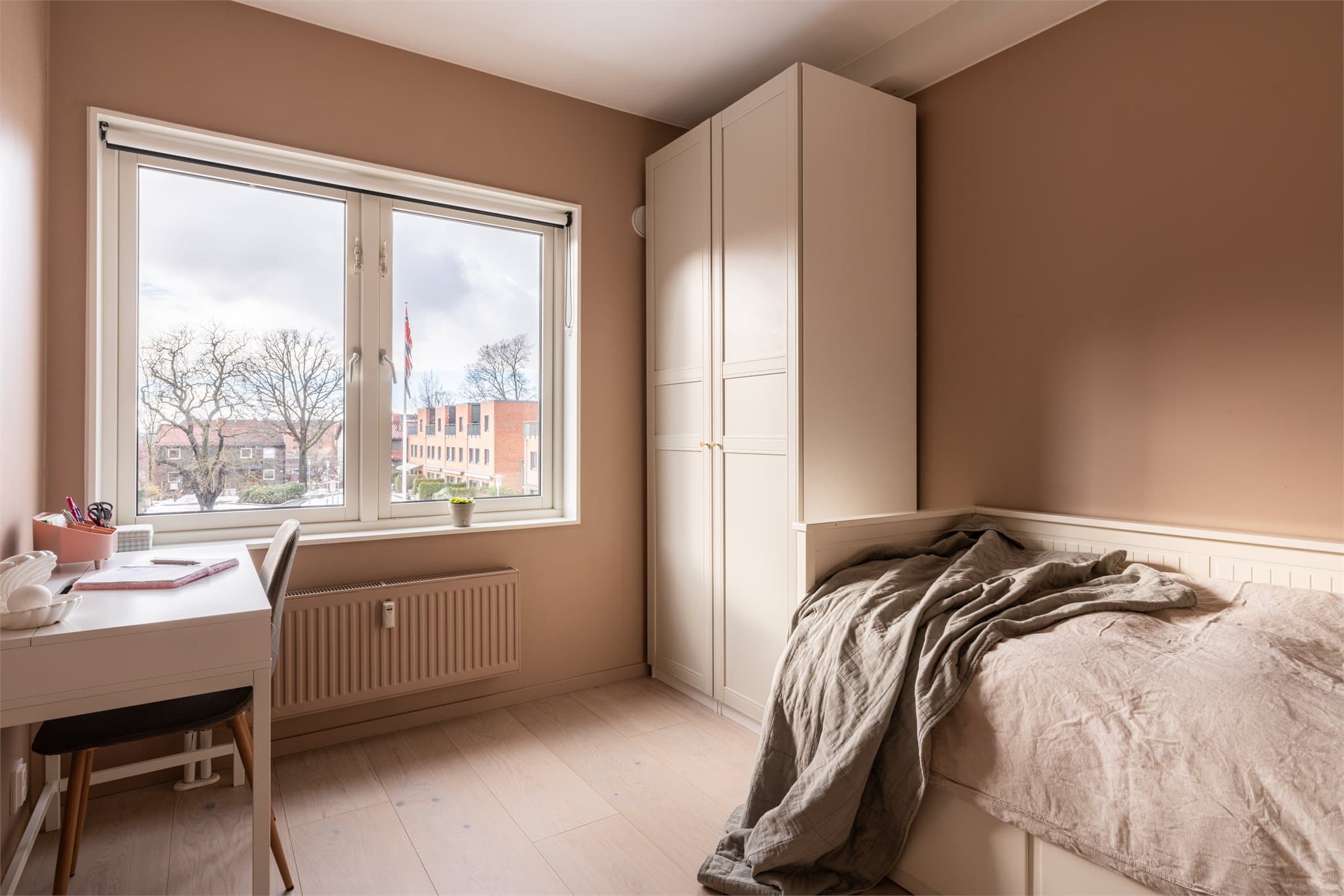 Lyst og innbydende soverom med store vindusflater som fyller rommet med naturlig lys.