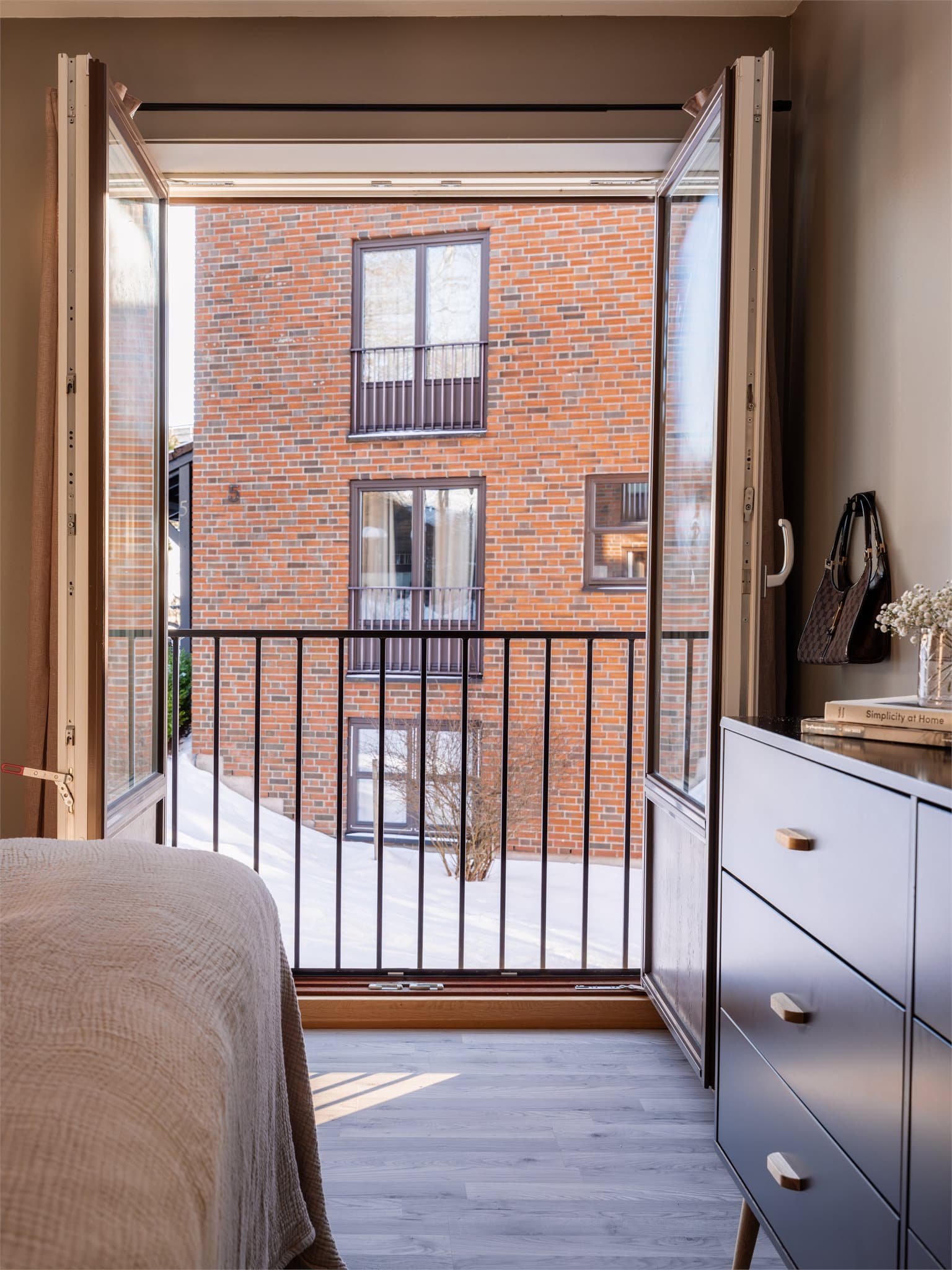 Den franske balkongen slipper inn frisk luft og skaper en åpen følelse i rommet.