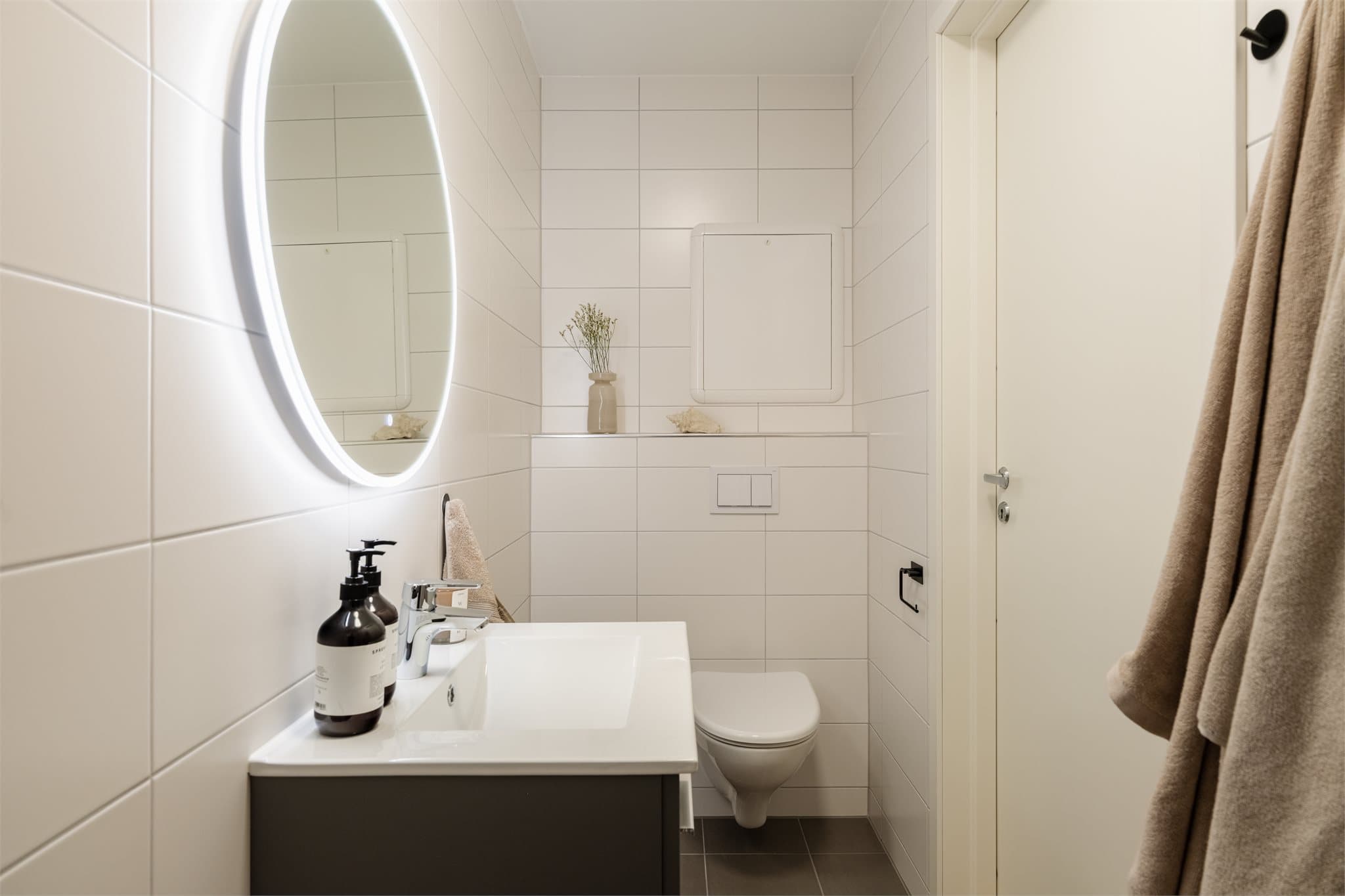 Badet er utstyrt med veggmontert toalett og servant.