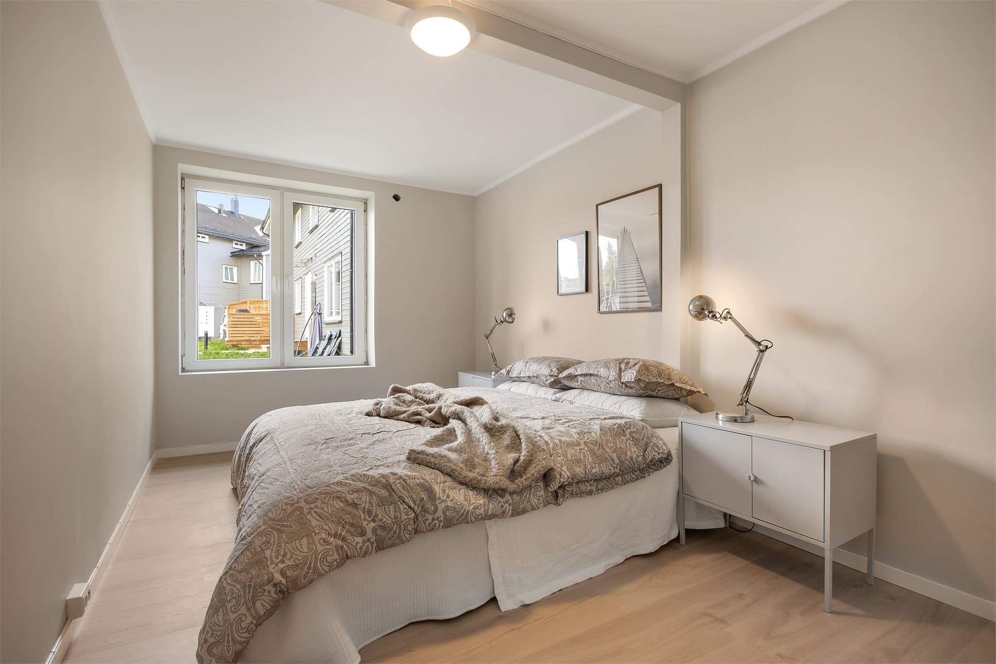 Boligen har to soverom med lyst laminatgulv og malte, slette vegg- og takflater.