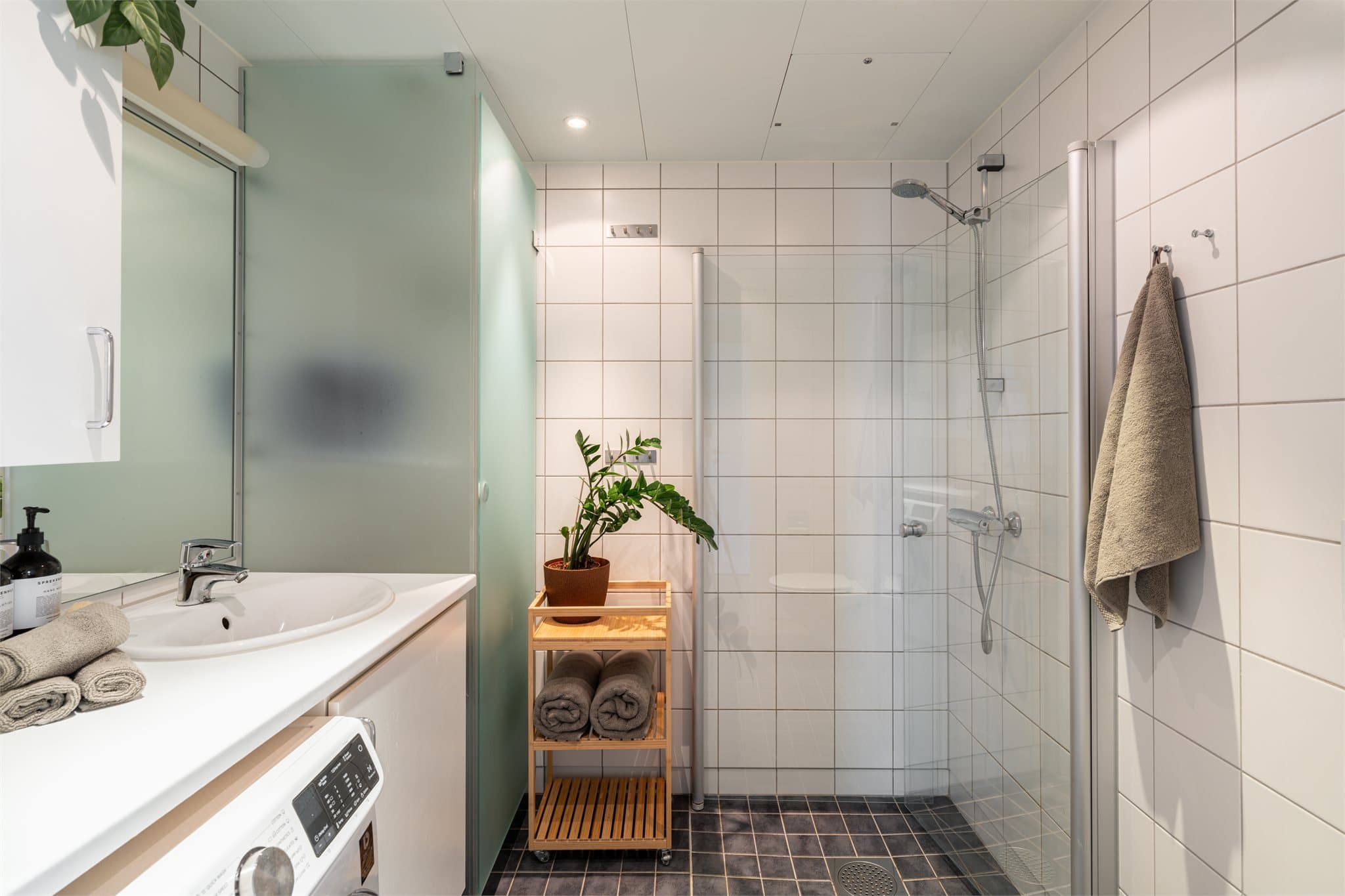 Lyst, flislagt baderom med varme i gulvet og downlights i himlingen.