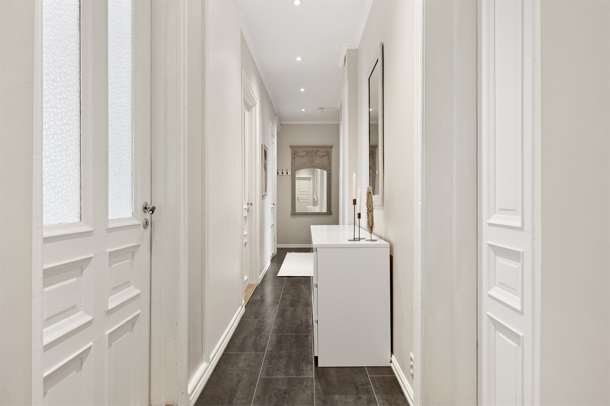 Lys og innbydende entré med downlights i himling.