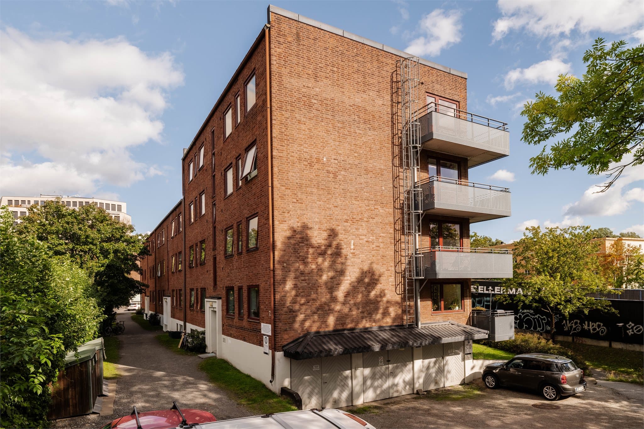 Klassisk bygård i tegl fra 1941, tilhørende Malerhaugen 1 Borettslag med felles parkeringsplasser.