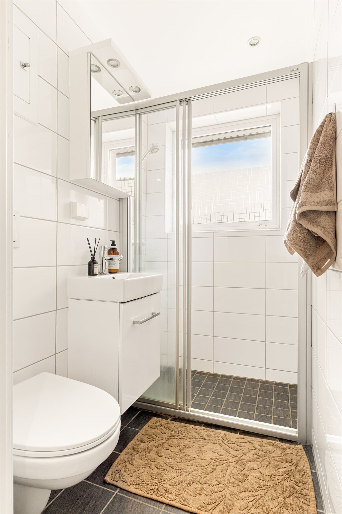 - Badet er innredet med heldekkende servant, vegghengt toalett og dusjvegg. Det er varmekabler i gulv. -