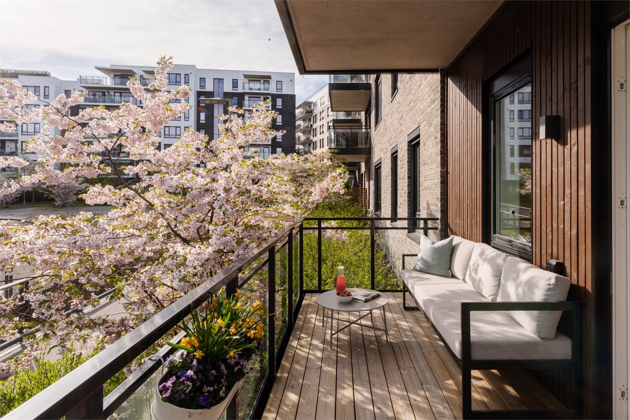 Utgang til en stor, sydvestvendt balkong på 12 m². Om våren skaper blomstrende kirsebærtrær en ekstra hyggelig atmosfære.