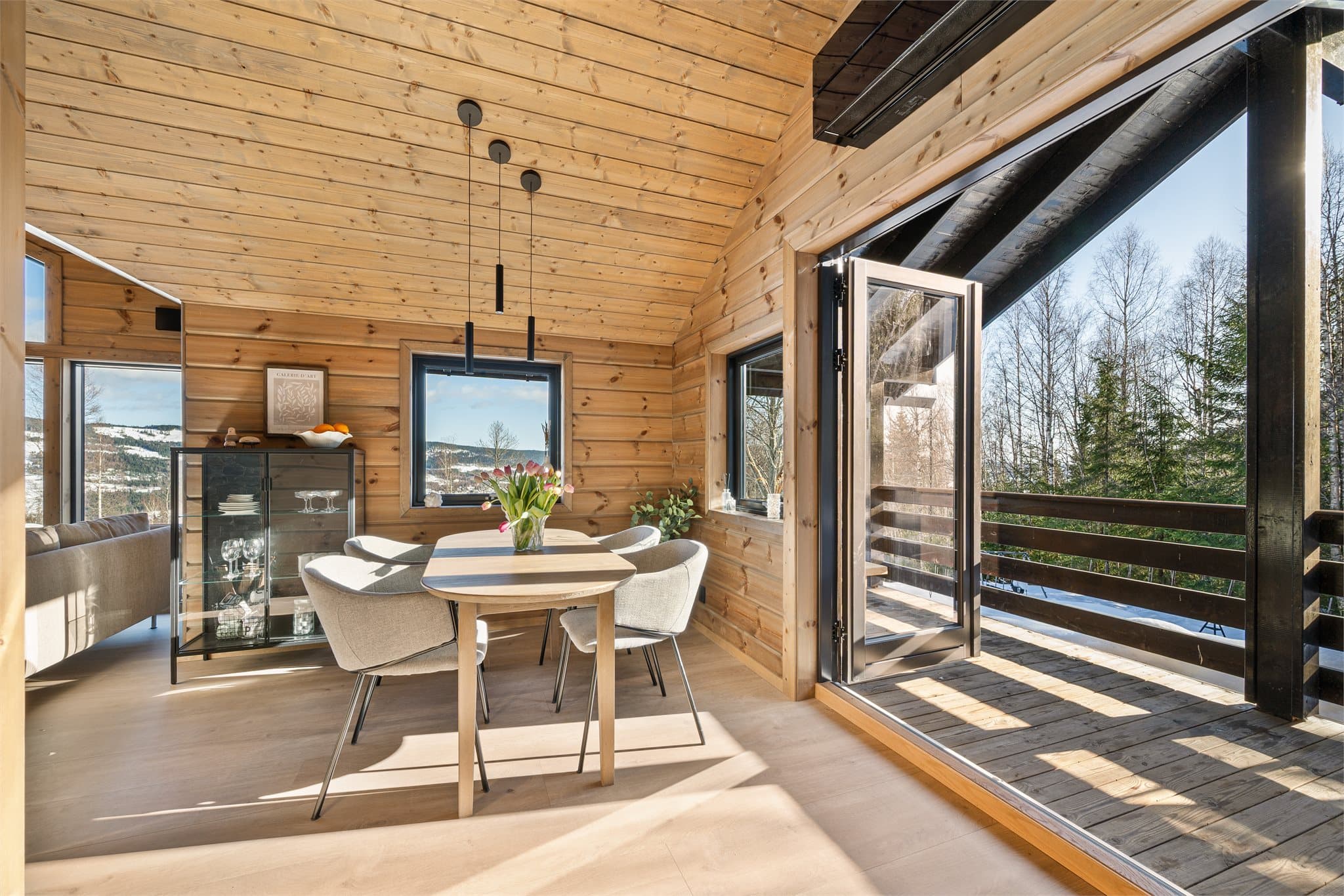 Fra spisestuen er det utgang gjennom en tofløyet balkongdør som leder direkte ut til den romslige, overbygde verandaen som omkranser hytta.
