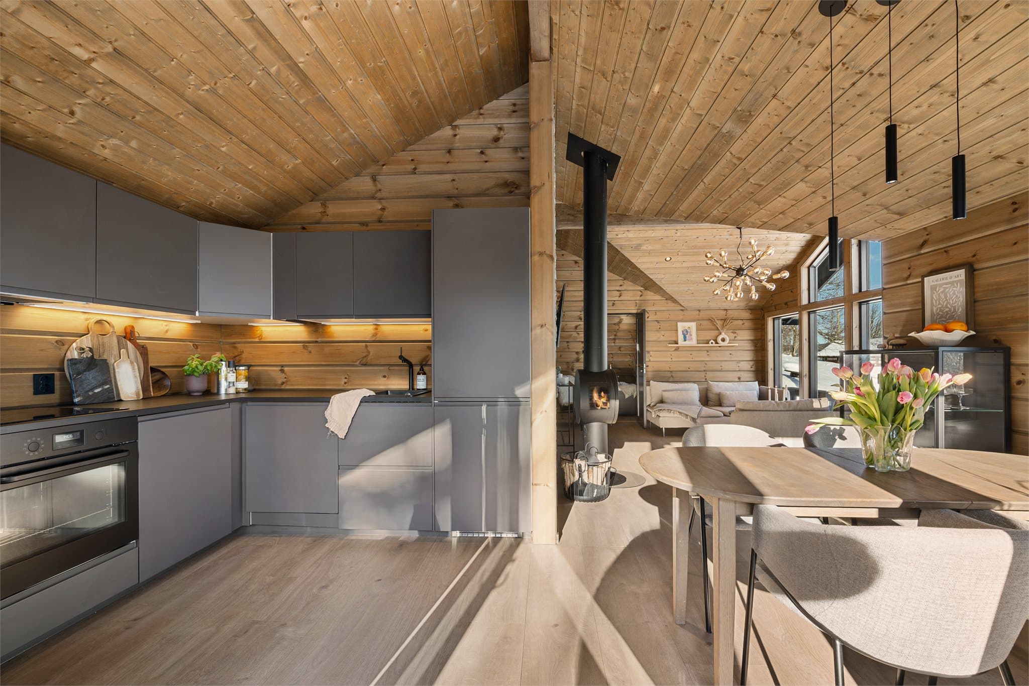 Kjøkkenet ligger naturlig plassert i den åpne stue- og spisestueløsningen, noe som gjør det enkelt å være sosial mens måltider tilberedes – et hyggelig samlingspunkt for både hverdag og gode hyttestunder.