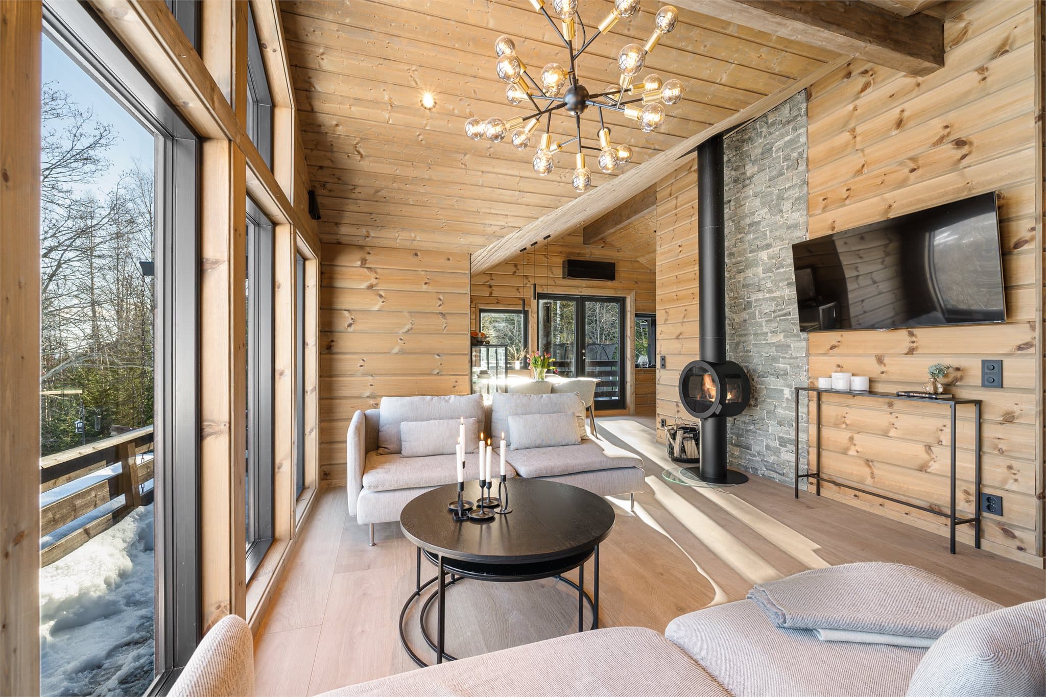 Den åpne og gjennomgående romløsningen skaper en naturlig flyt fra sofagruppen i stuen og videre til spisestuen, som ligger i forlengelse av den hyggelige kjøkkenkroken.