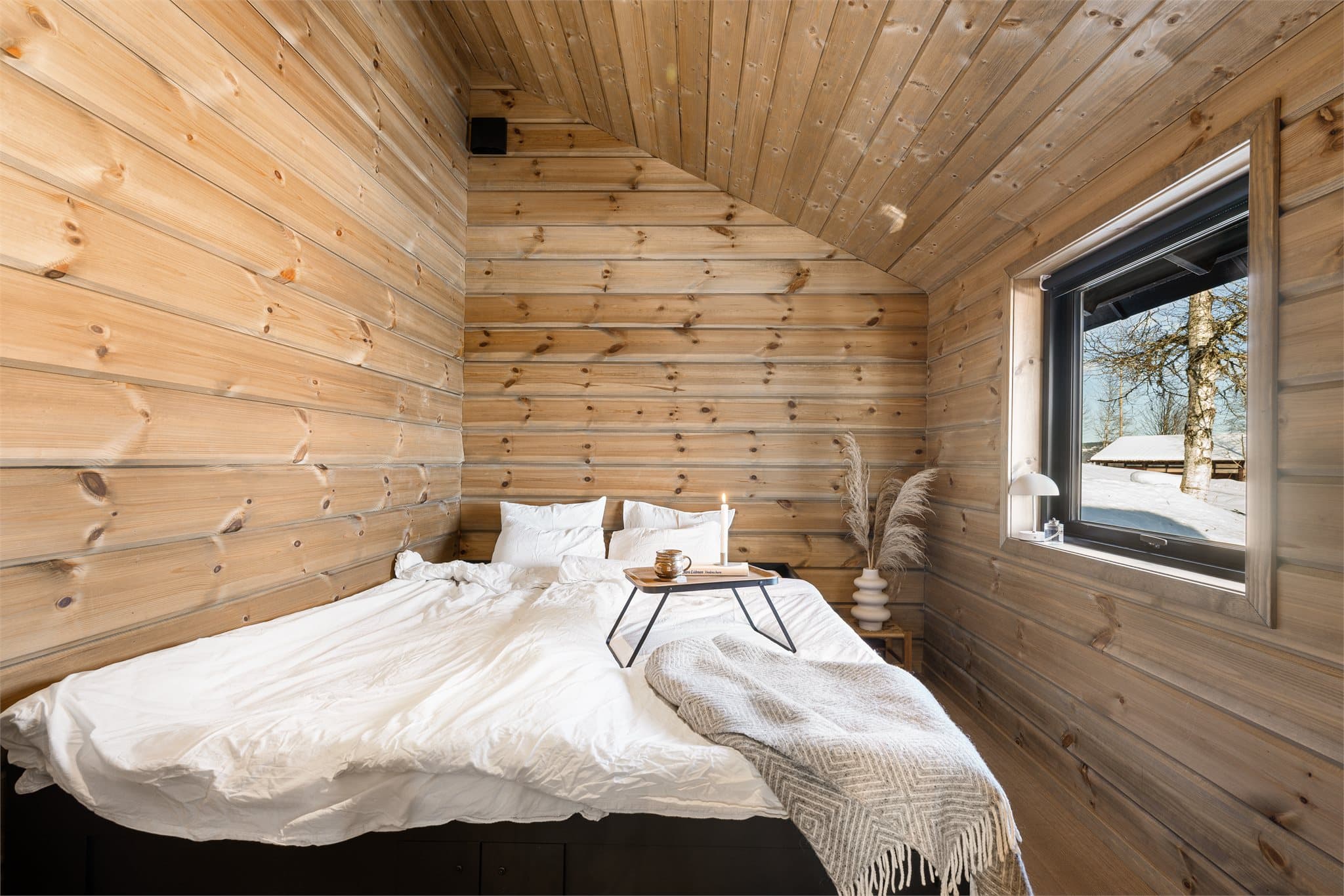 Soverommet som ligger i tilknytning til stuen, fremstår luftig og innbydende takket være den gode takhøyden med skråtak.