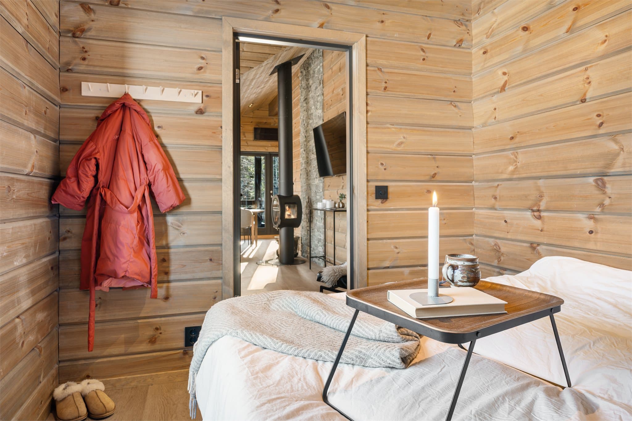 Hovedsoverommet er innbydende og lunt, innredet med en utrekkseng som enkelt kan gjøres om til dobbeltseng – perfekt for en avslappende natt på hytta. Fra rommet er det enkel adkomst til stuen, som gjør det lett å kombinere privatliv og sosialt samvær.