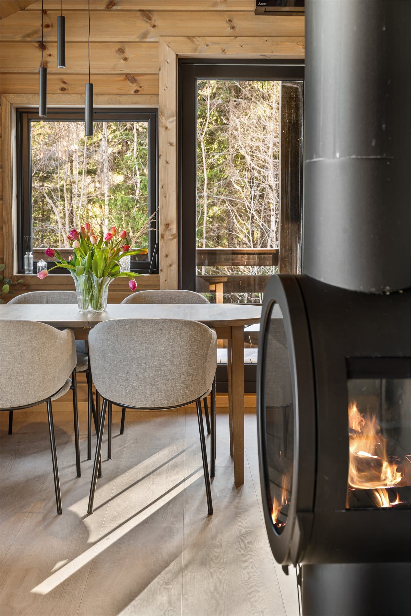 Den moderne, runde peisovnen blir et naturlig midtpunkt i rommet – flammene skaper en lun og stemningsfull atmosfære som virkelig forsterker følelsen av ekte hytteliv.