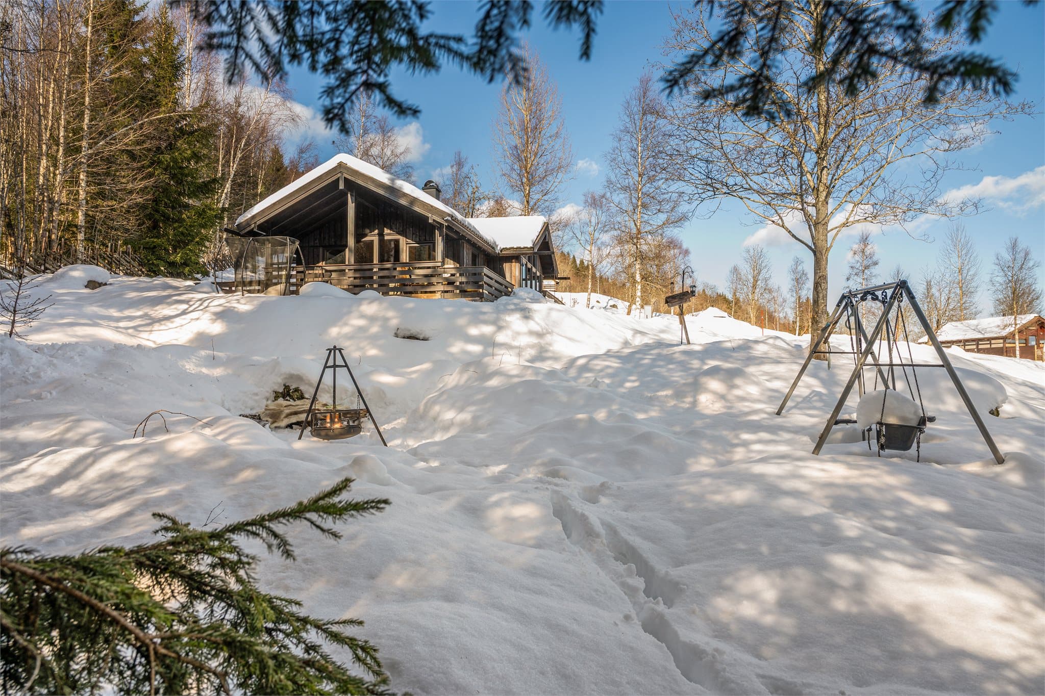 Nedenfor hytta er det laget en flott bålplass med sittebenker rundt bålpanna – perfekt for koselige kvelder med familie og venner under stjernehimmelen. For de minste, og de som bare er unge til sinns, medfølger også huskestativ og trampoline.