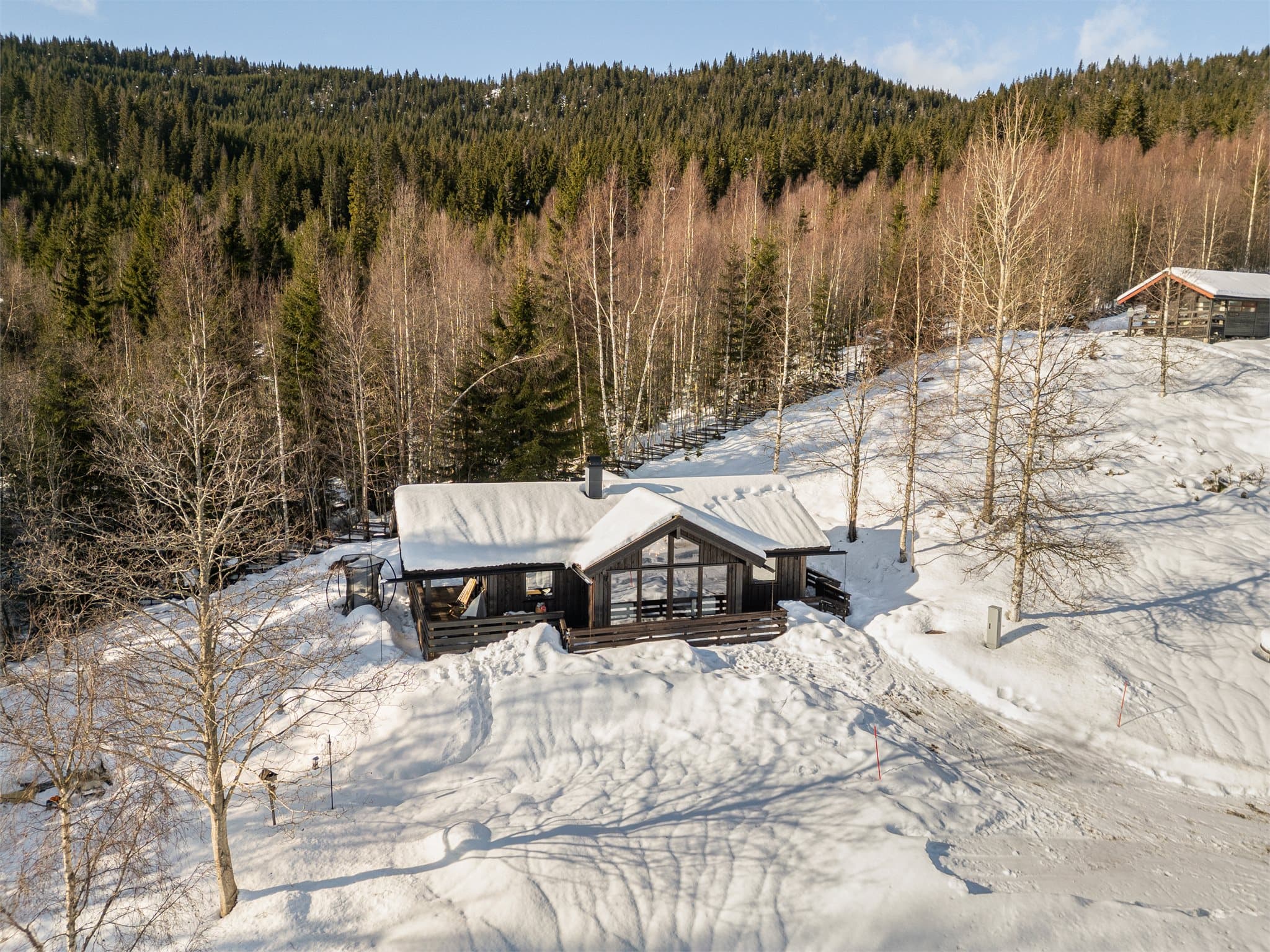 Det karakteristiske utstikket fra stuedelen gir hytta et moderne og spennende uttrykk, samtidig som det skaper ekstra takhøyde og en imponerende, luftig romfølelse inne.