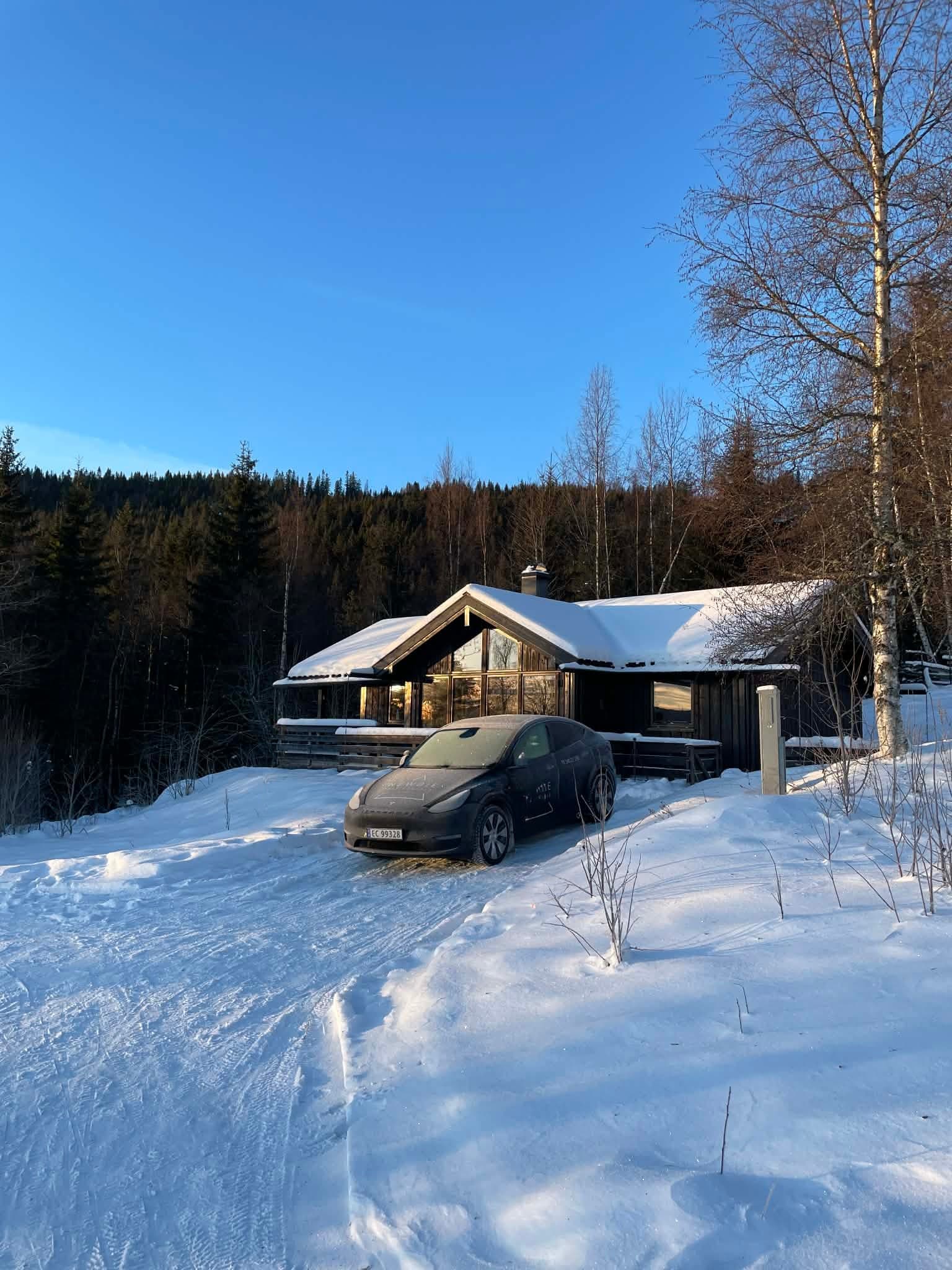 Selgers private bilde: Det er montert ladeboks for El-bil på yttervegg i kort avstand til biloppstillingsplassen foran hytta.