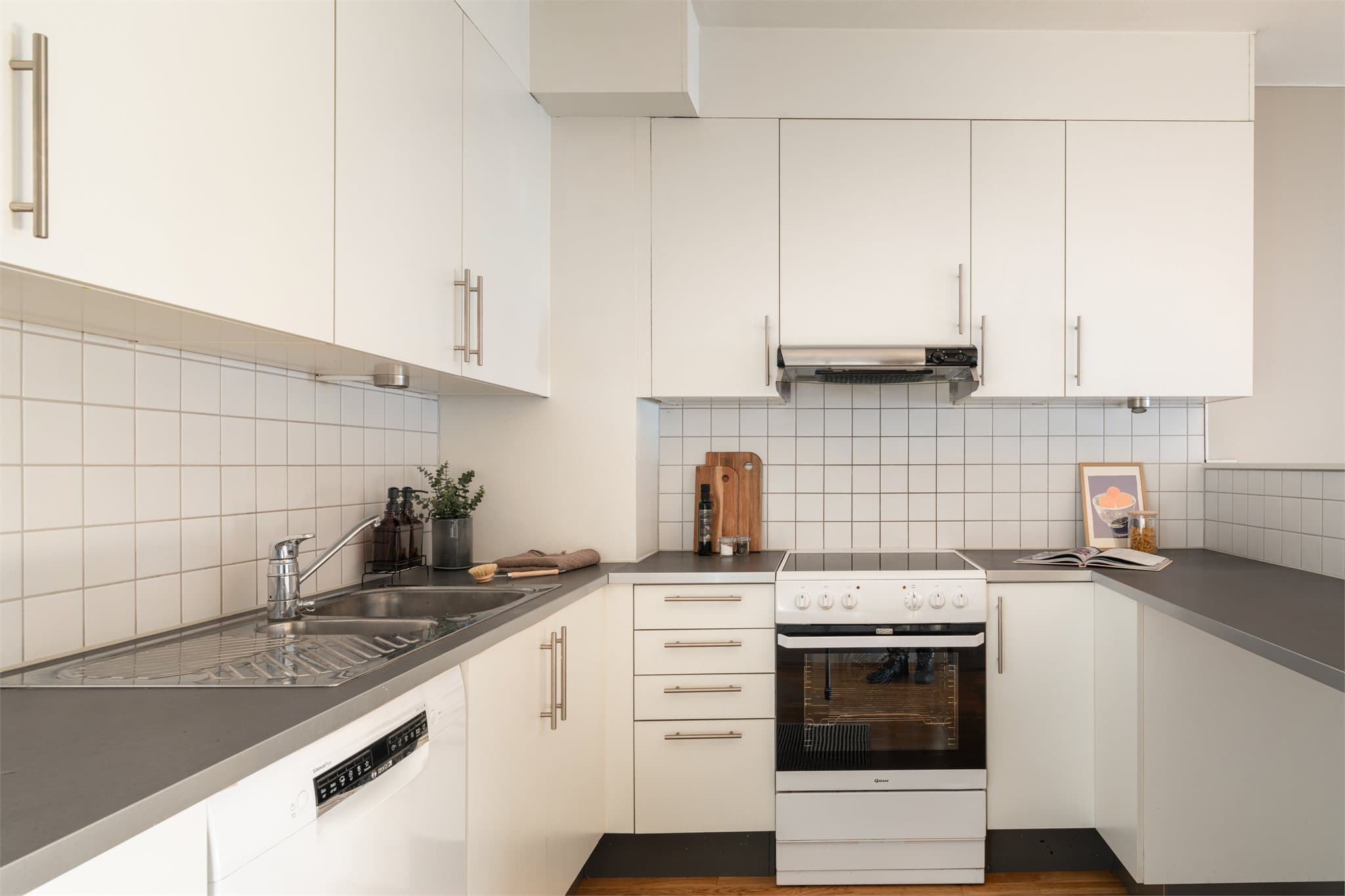 Åpen planløsning mellom kjøkken og stue skaper en lys og sosial møteplass.