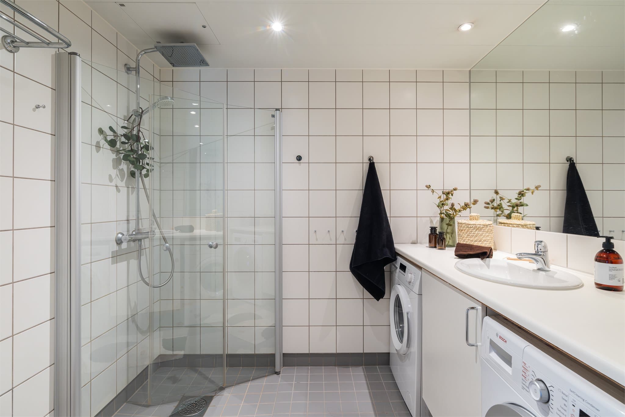 Tidløst baderom med stort speil og benkeplate