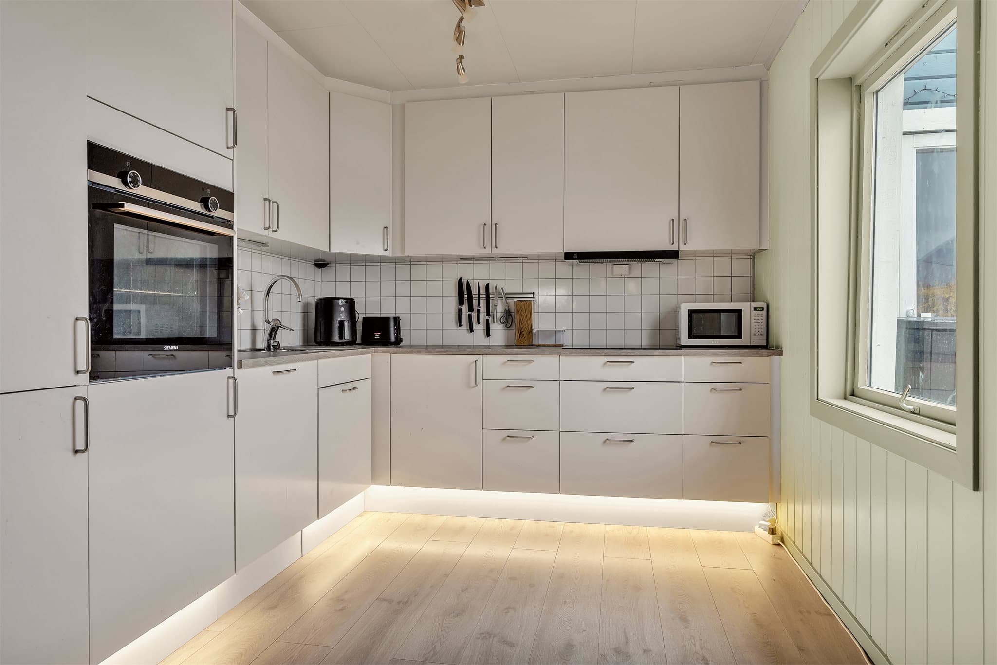 Kjøkkenet i 1. etasje har innredning med glatte fronter og benkeplate i laminat.