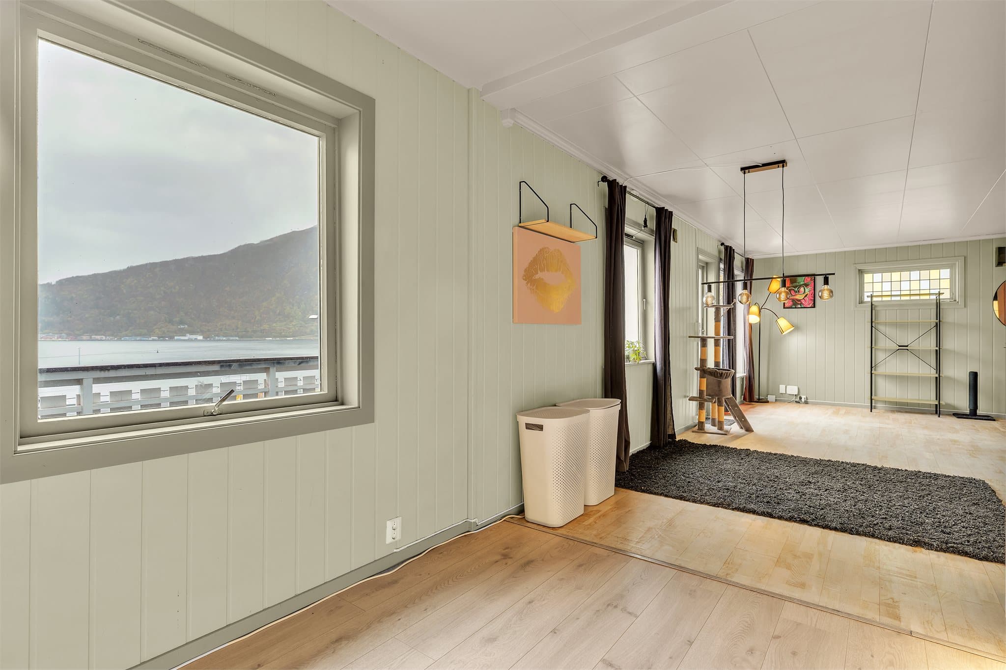 Vinduene i stuen slipper inn dagslys og vender mot fjordlandskapet.