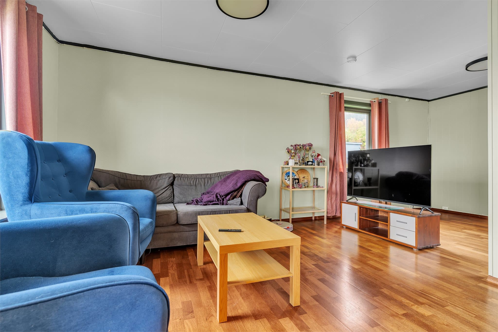 Romslig stue med god plass til sofa og tv-seksjon.