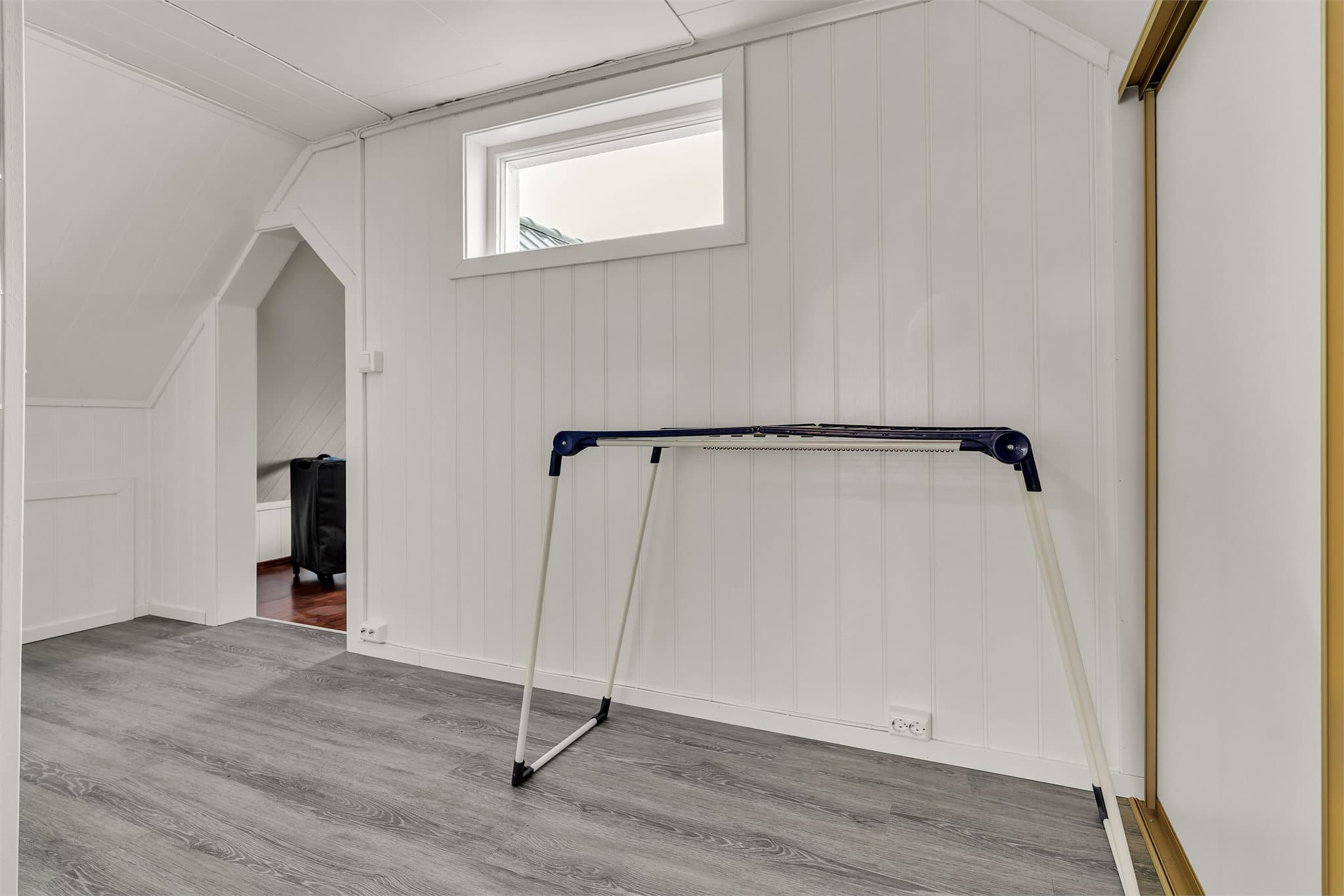 Gangareal på loftet med skyvedørsgarderobe og praktisk oppbevaringsplass.