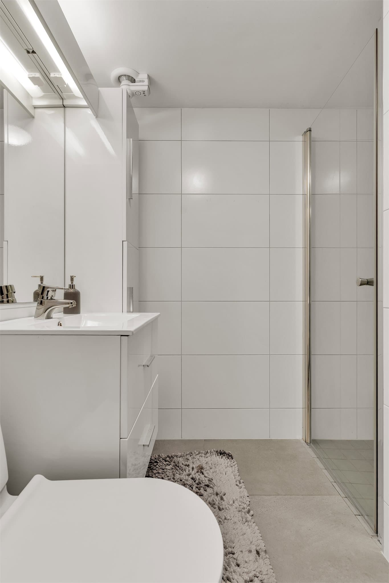 Badet i kjelleren er fra 2018 med flislagte vegger, dusjhjørne og baderomsinnredning. Gulvet har varmekabler.