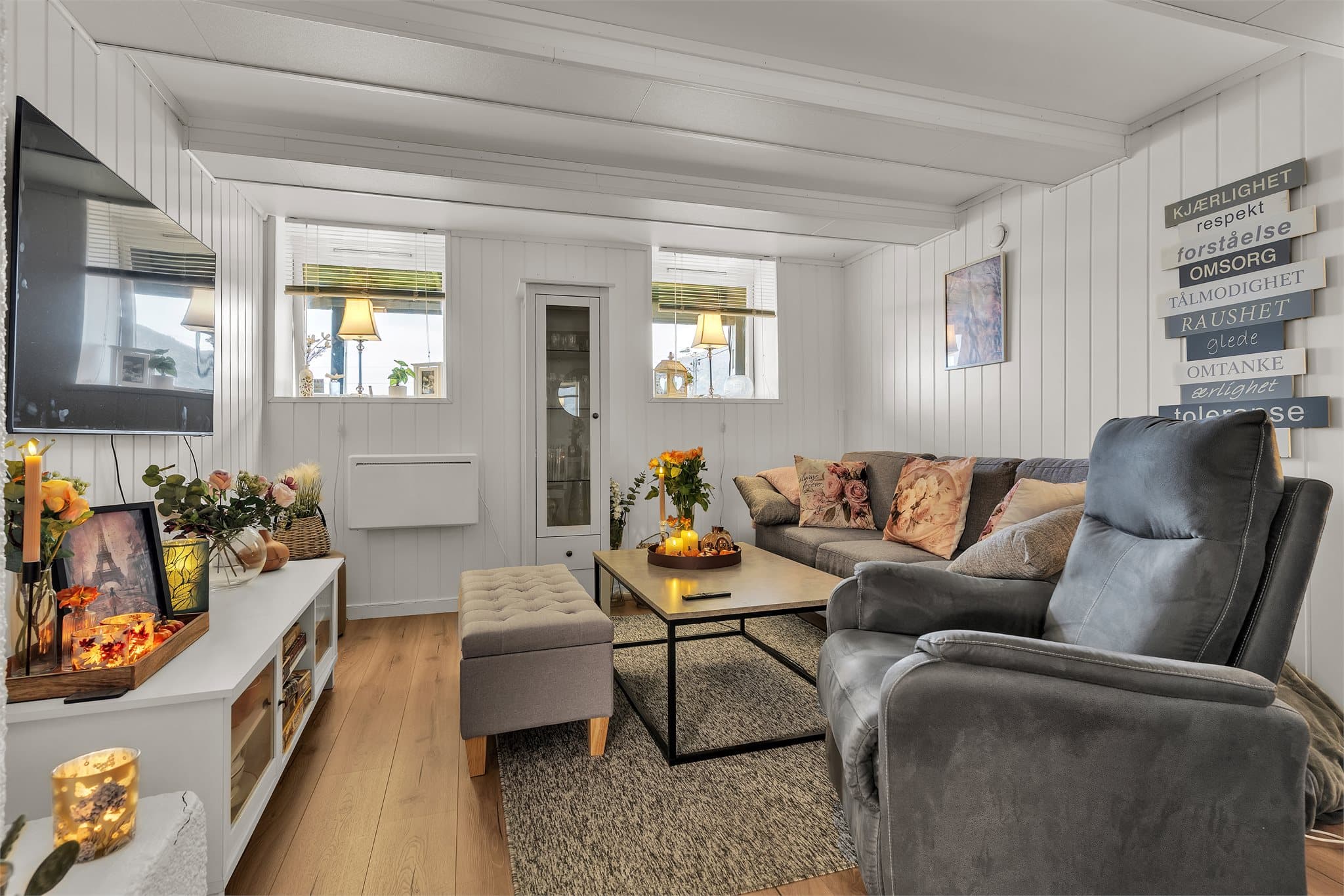 Stuedelen i kjelleren har laminatgulv, panelvegger og plass til sofagruppe.