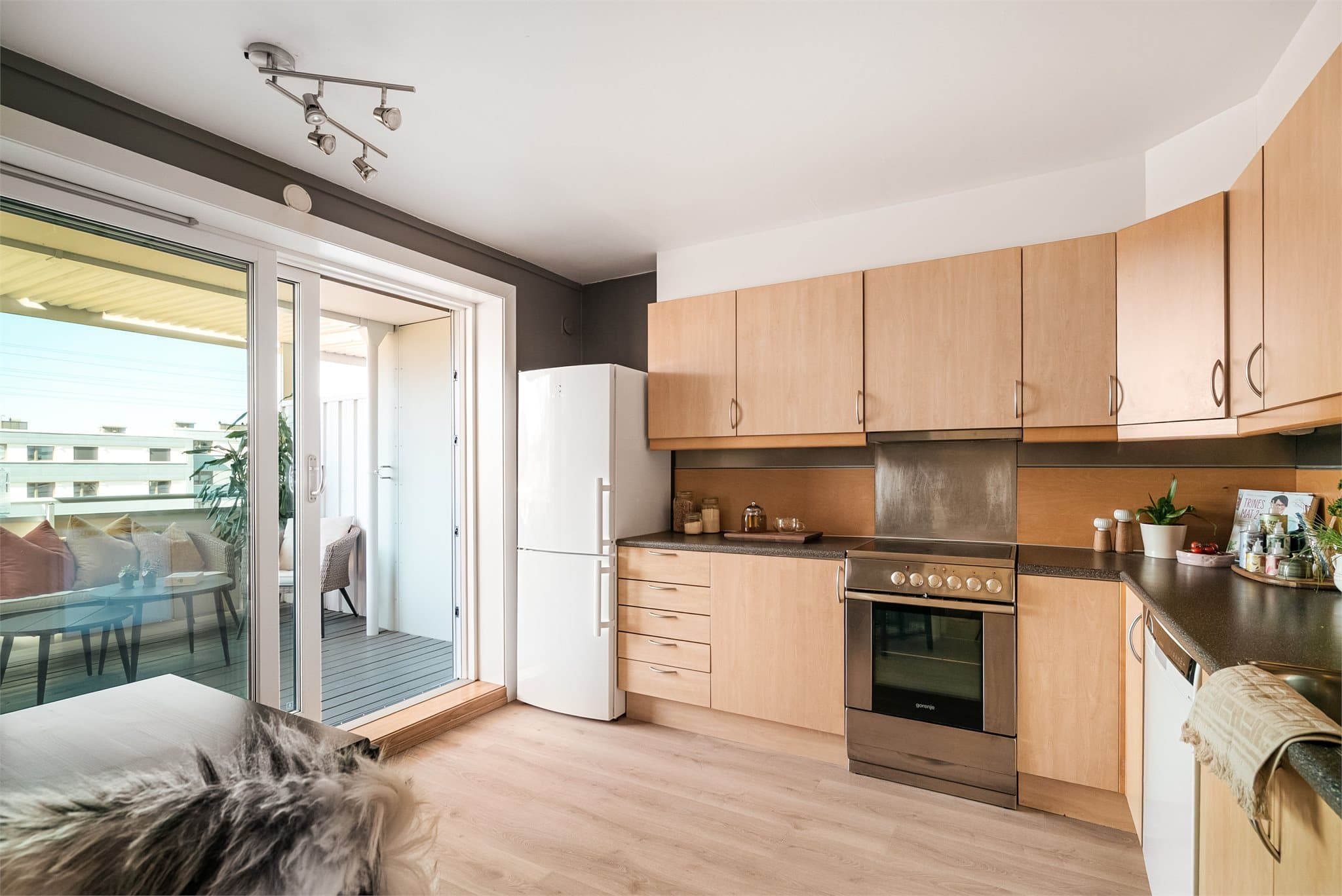 L-formet kjøkken med god oppbevaringsplass og glatte fronter.