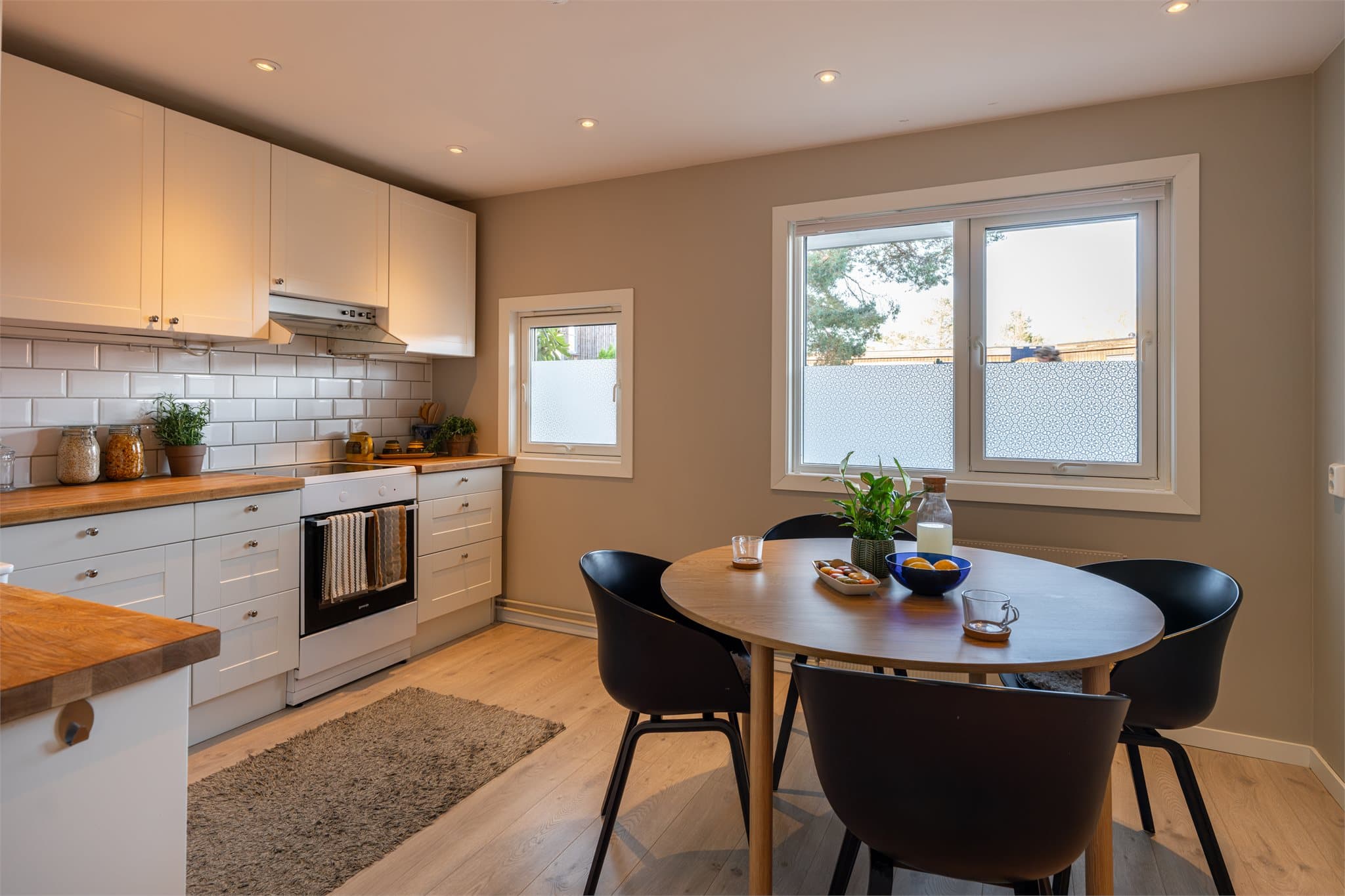 Kjøkkenet har en moderne innredning i lyse fargetoner, og rommet har god plass til et stort spisebord som skaper en naturlig samlingsplass for familie og venner.