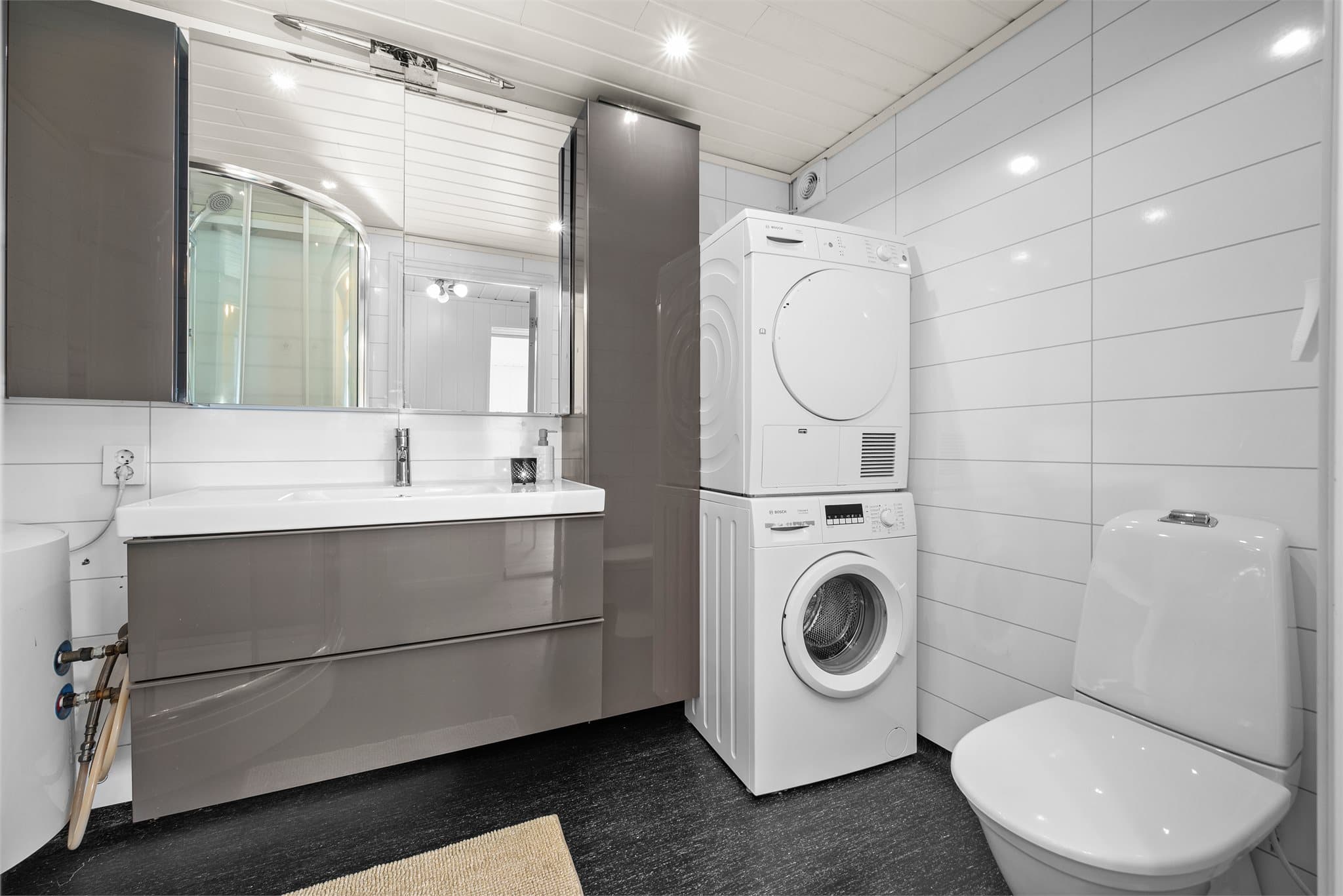 Badet i underetasjen måler ca. 4 kvm og er innredet med servantinnredning, toalett og dusjkabinett. Det er også opplegg for vaskemaskin og tørketrommel.