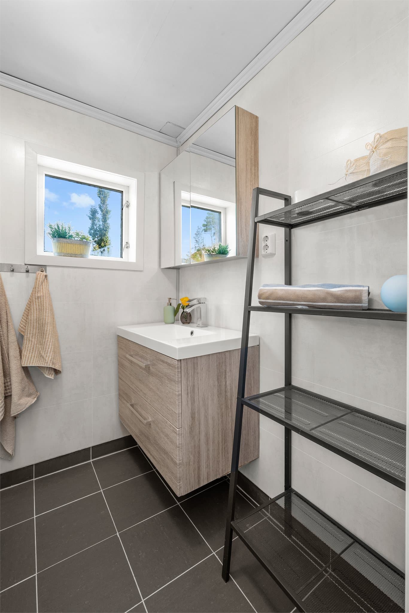 Det andre badet har servant innredning, dusjkabinett og vegghengt toalett.