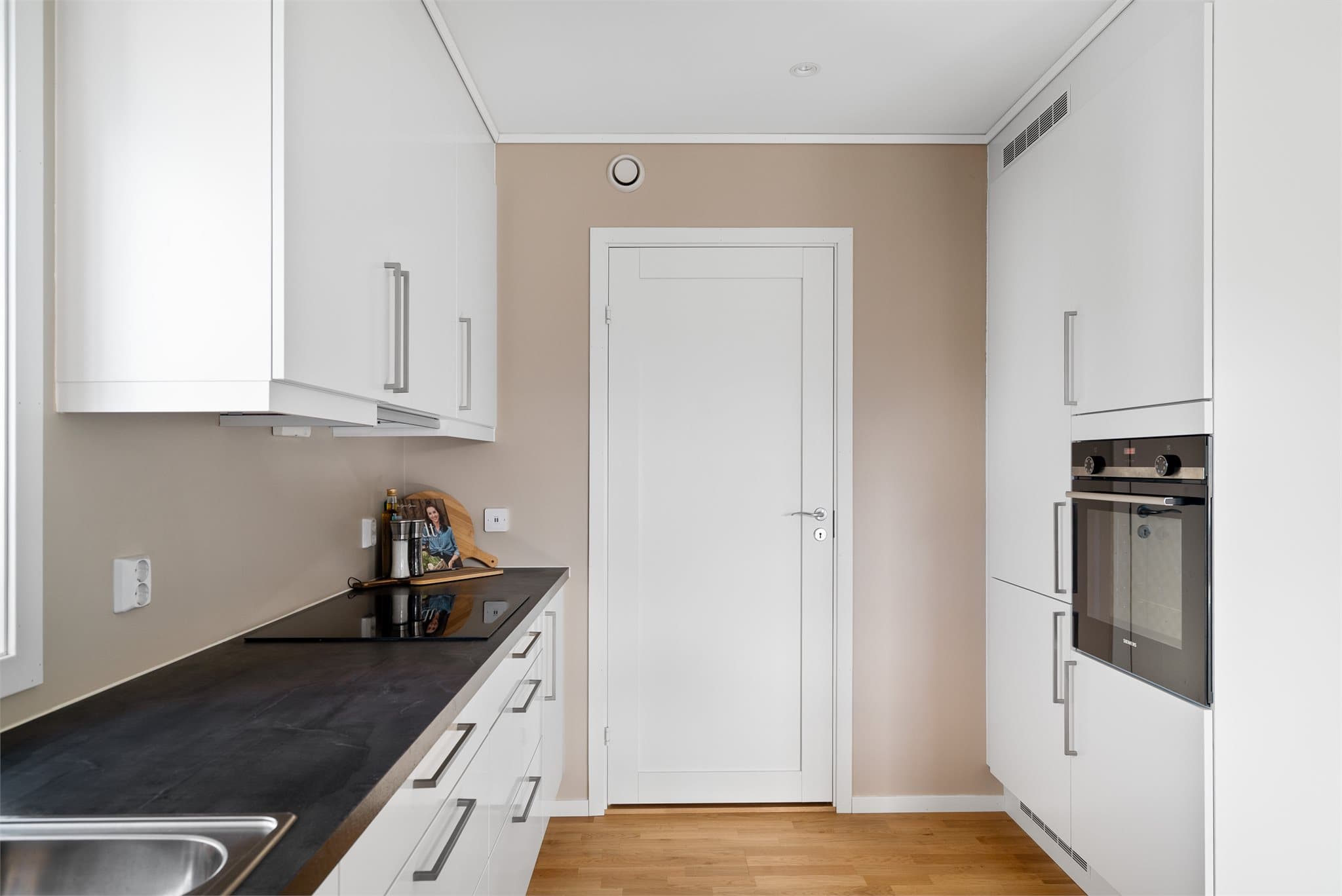 Integrerte hvitevarer og god skapplass gir et funksjonelt kjøkken.