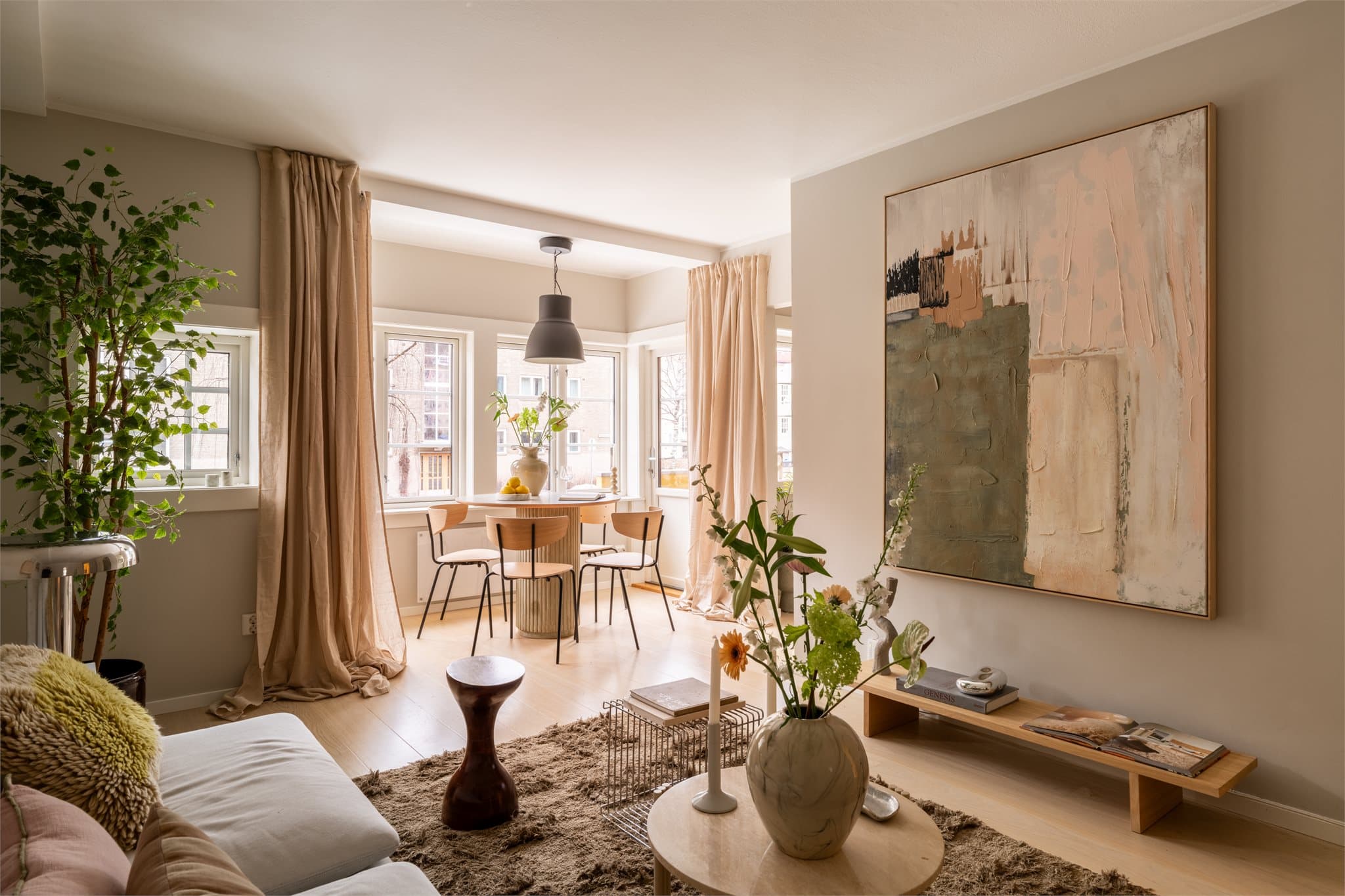 Åpen løsning mellom stue og kjøkken, men med vegg i mellom som lager en fin soneinndeling og naturlige soner for møblering.