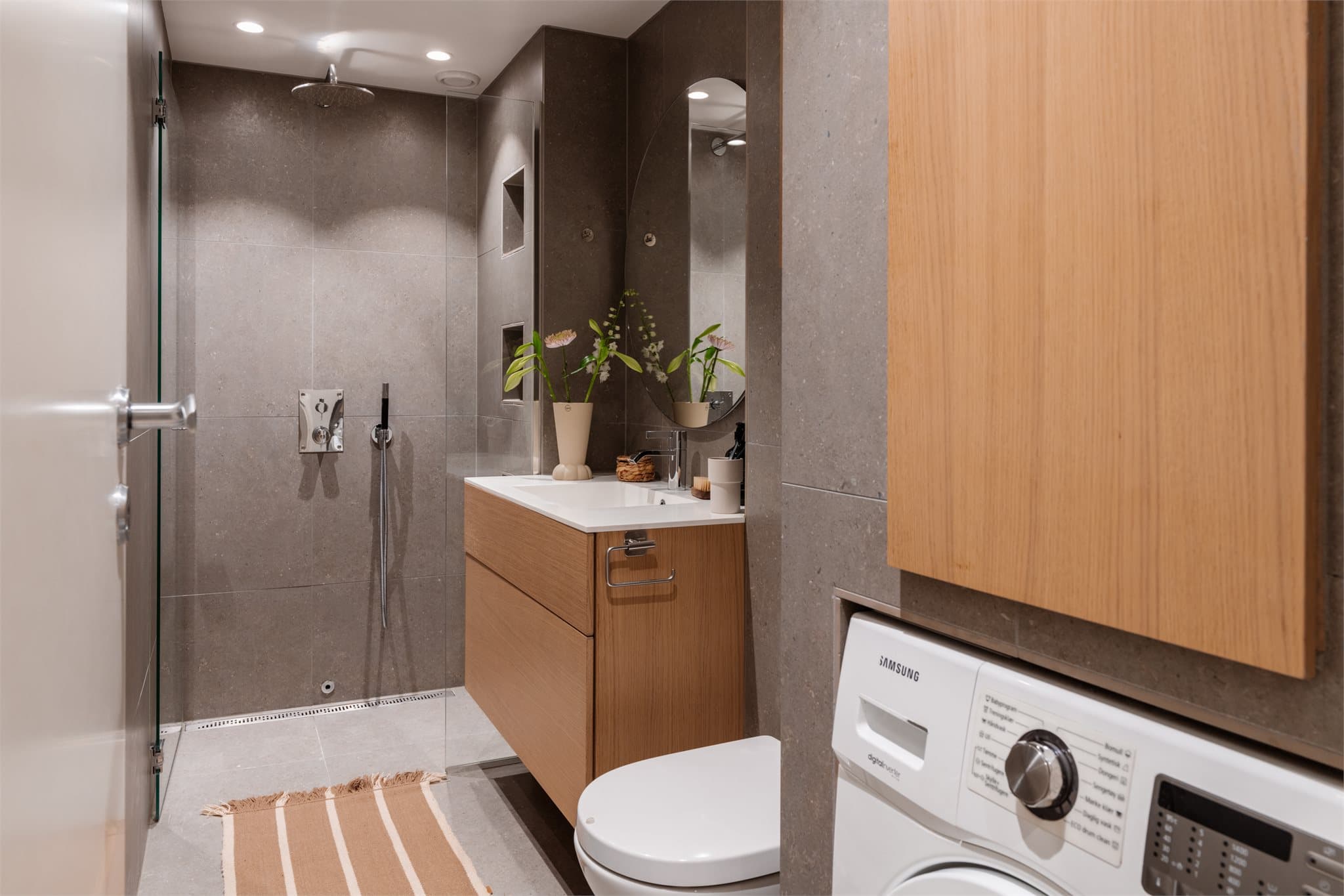 Her er det vegghengt toalett med innebygget sisterne og opplegg for vaskemaskin.