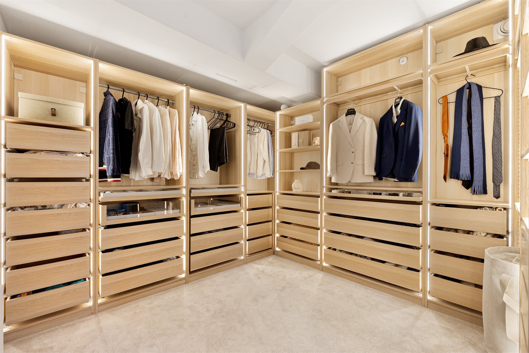Delikat walk-in-closet med elegant belysning og oversiktlig oppbevaring.
