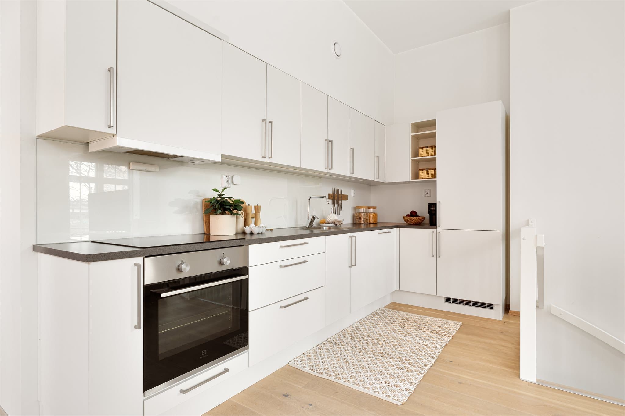 Kjøkkenet er lyst og moderne med slette fronter og integrerte hvitevarer.