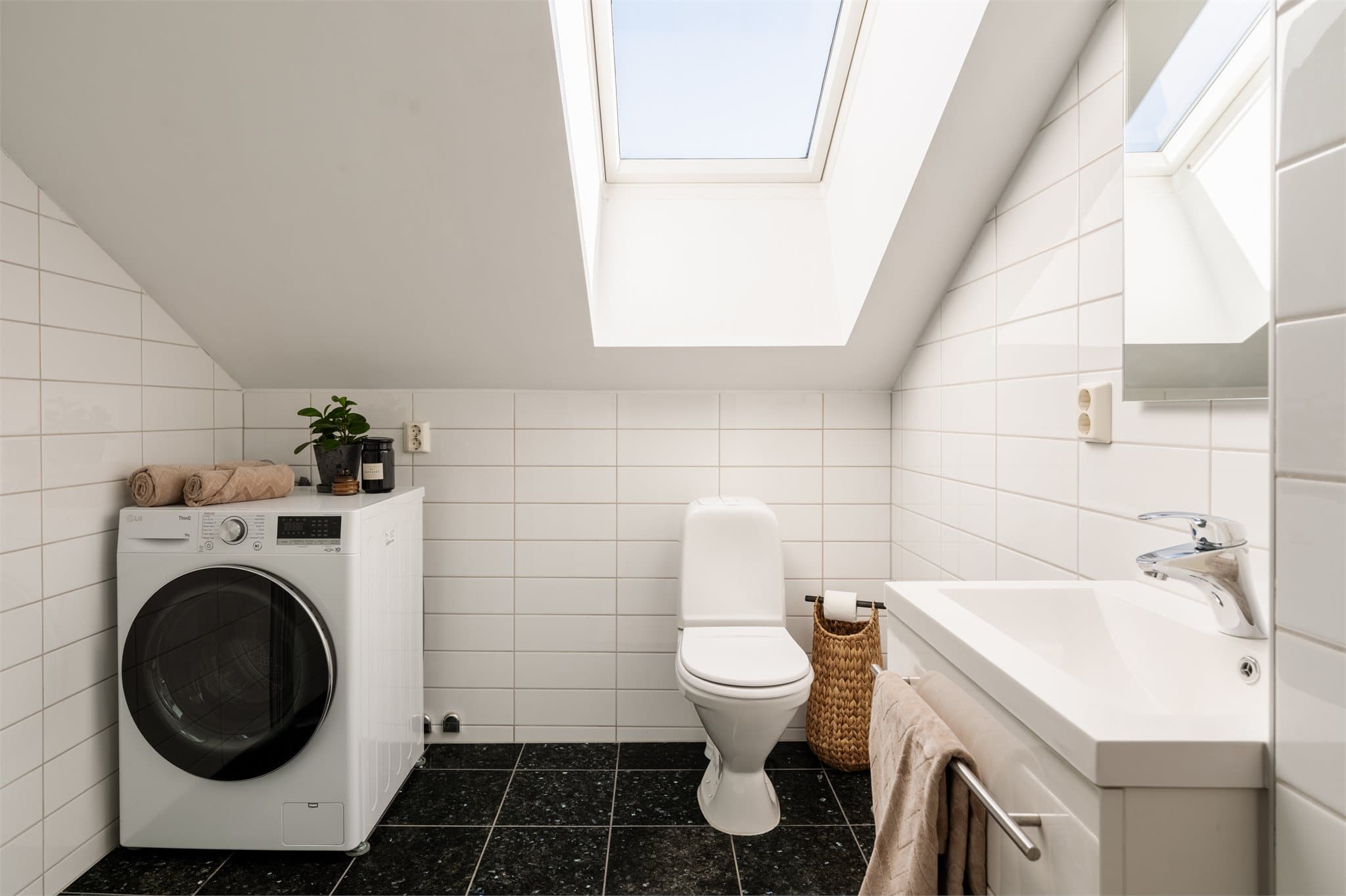 Flislagt bad med elektriske varmekabler i gulvet og opplegg for vaskemaskin.