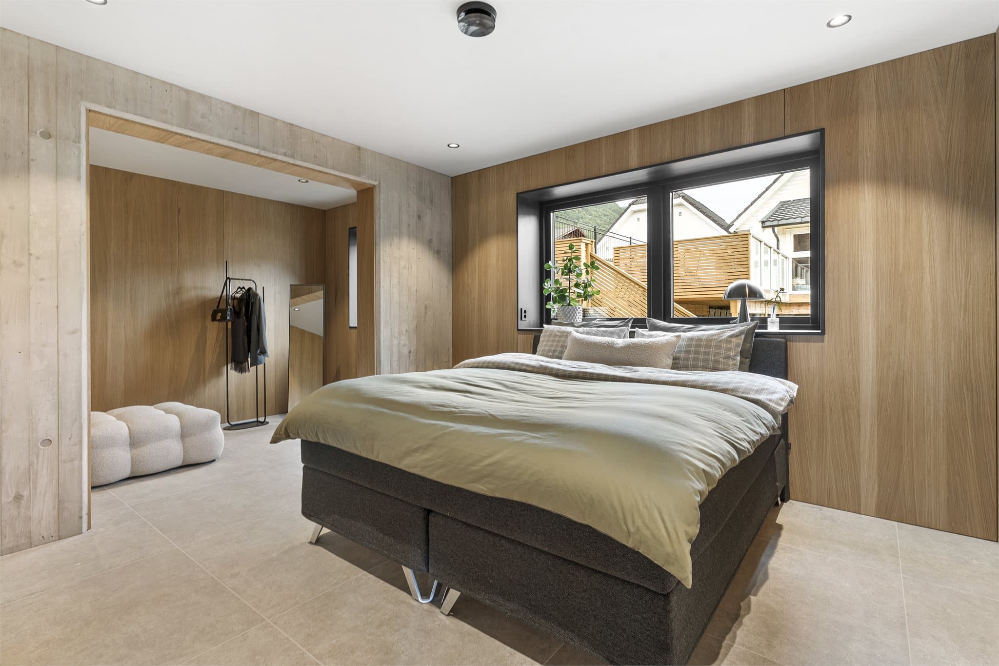 Hovedsoverommet (2) har storformatfliser med vannbåren gulvvarme, eikefinerte veggflater, detaljer i betong og downlights. I direkte tilknytning ligger et romslig tilleggsrom som i dag er holdt åpent og fleksibelt.