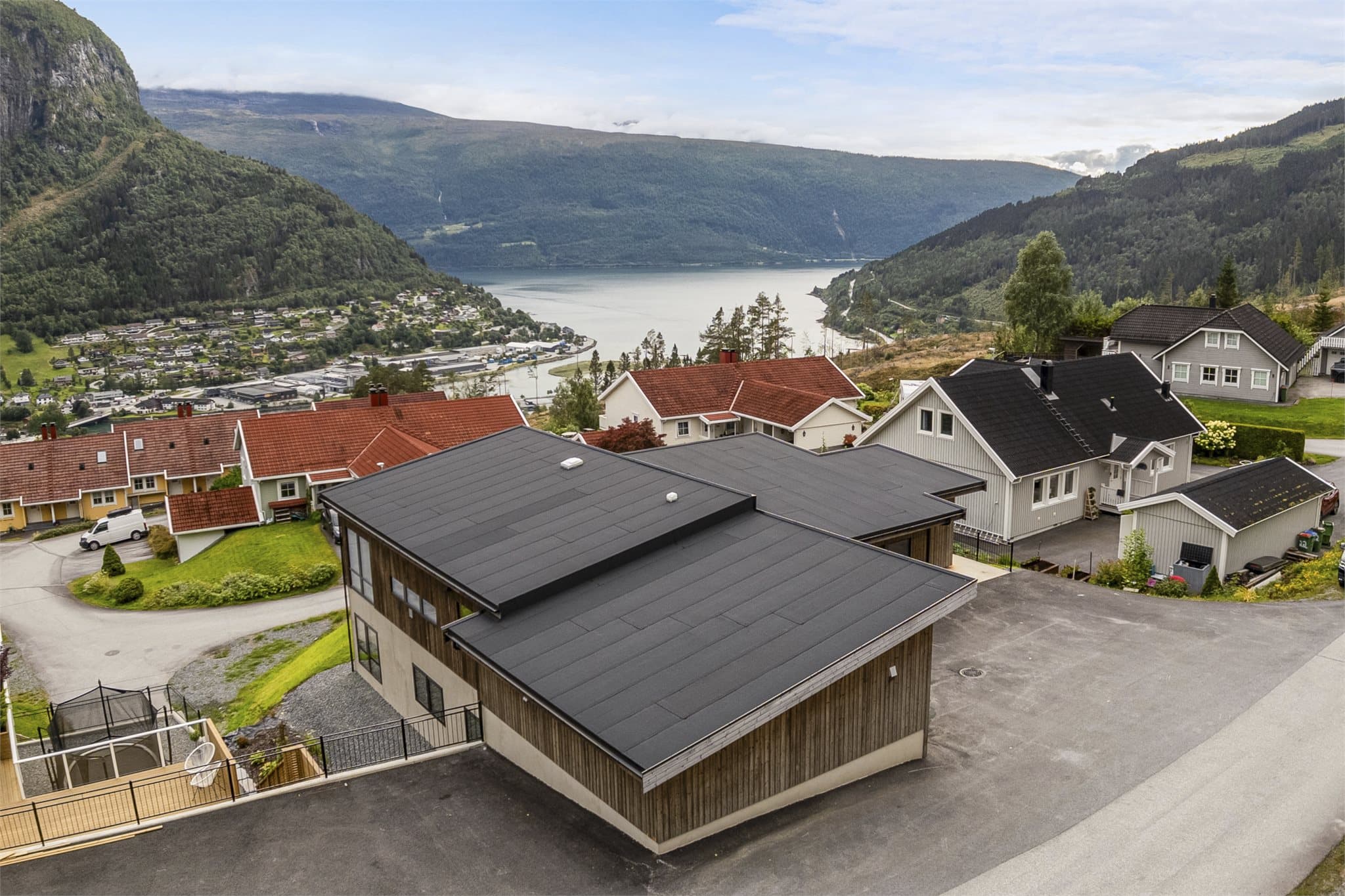 Tomten er pent opparbeidet og i stor grad utjevnet, med asfalterte arealer, plen og enkel beplantning. De åpne omgivelsene og gode utearealene gir fine rammer for både lek og opphold, og gjør eiendommen godt egnet for barnefamilier.