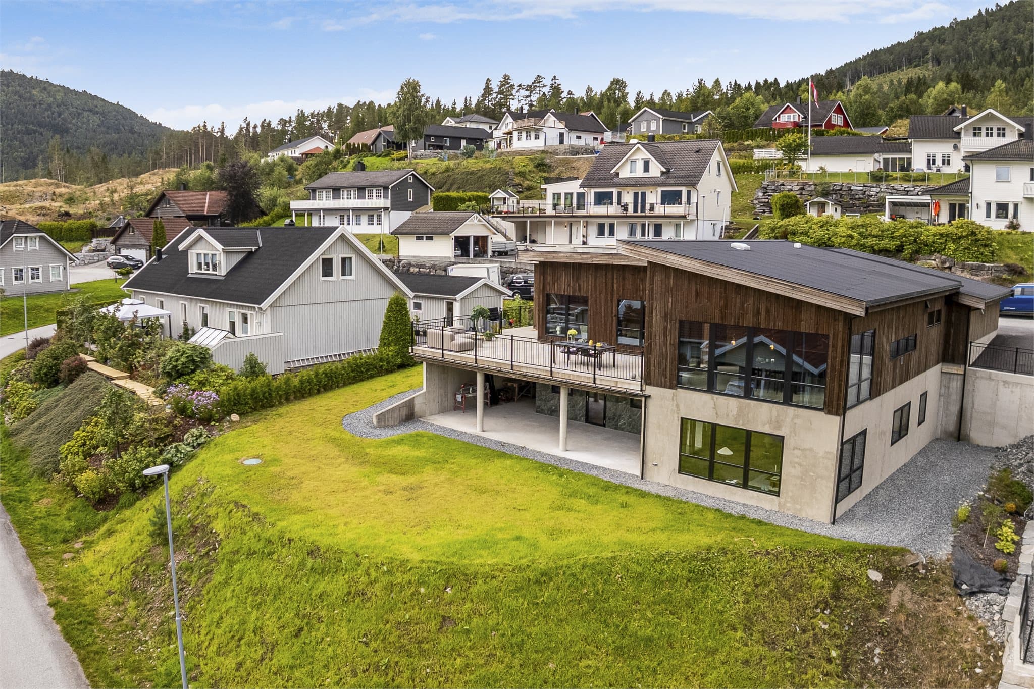 Utvendig er boligen kledd med Adelfuru, jernvitriolbehandlet malmfuru, som gråner naturlig over tid og ikke krever tradisjonell maling eller beis. Rekkverkene er utført i varmgalvanisert og pulverlakkert stål fra Smihuset.