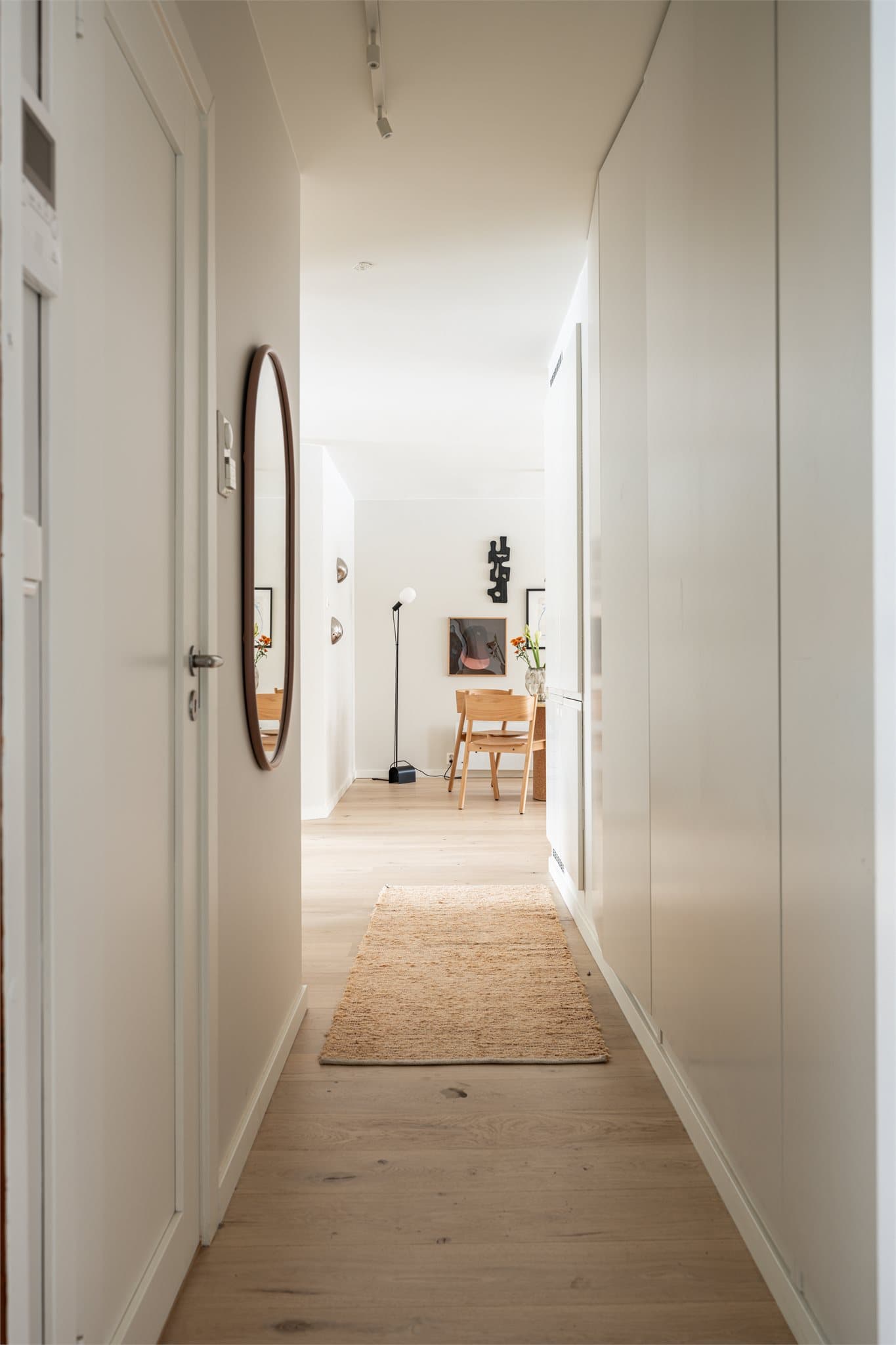 Gangen fremstår lys og innbydende, med mulighet for oppheng av ytterklær i velutformede integrerte garderobeskap.