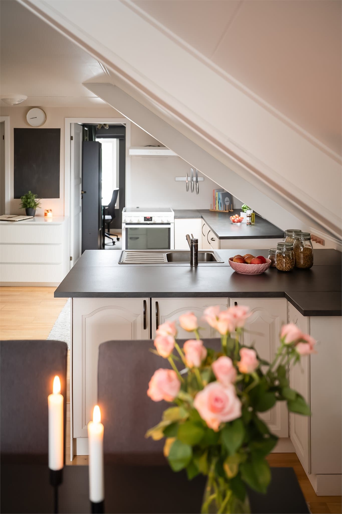 Delvis åpen stue- og kjøkkenløsning på 27 kvm med naturlige soner, der sofakroken er naturlig adskilt fra kjøkkenet.