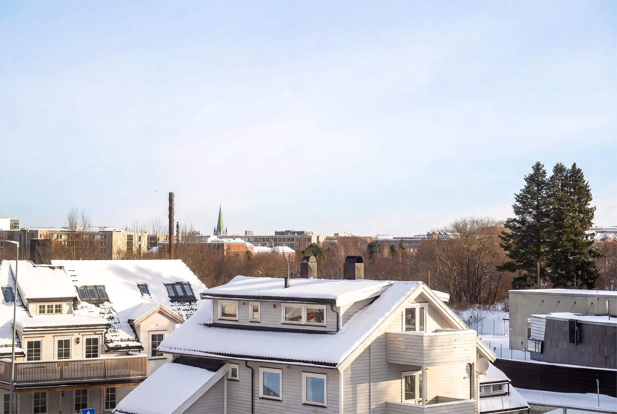 Fra leiligheten har man fin utsikt mot nærliggende boligområder og natur.