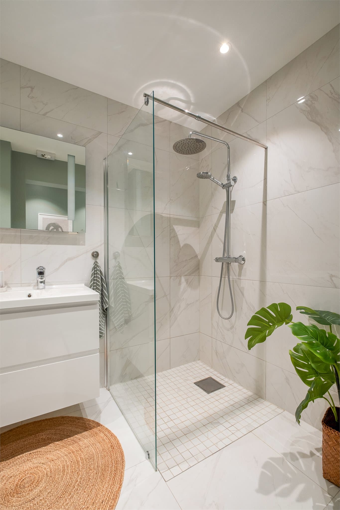 Badet er moderne og innredningen består av servantinnredning, vegghengt toalett og dusjhjørne med regndusj.