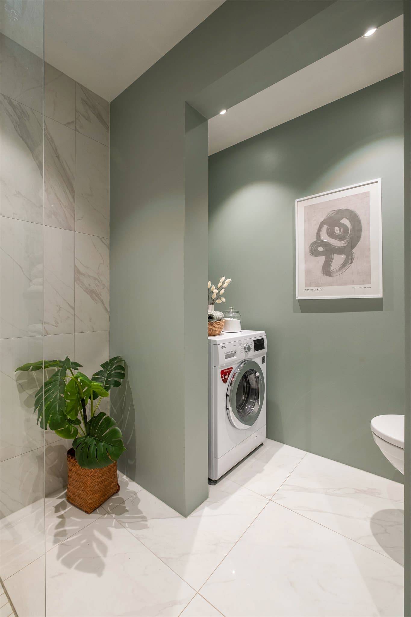 Praktisk planløsning hvor toalett og opplegg for vaskemaskin er i en egen nisje.