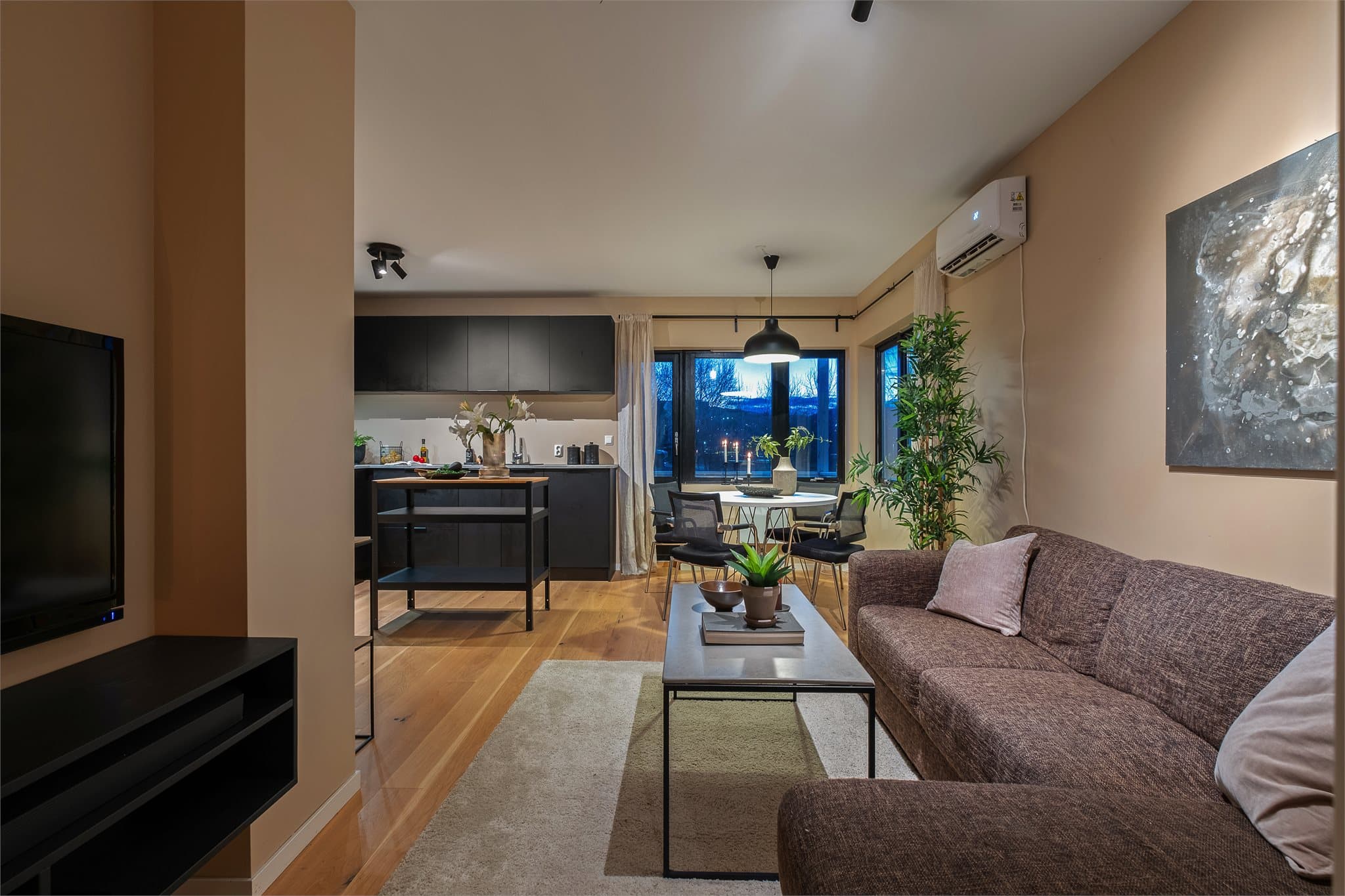 Den åpne løsningen mellom stue og kjøkken gir en sosial og luftig romfølelse.