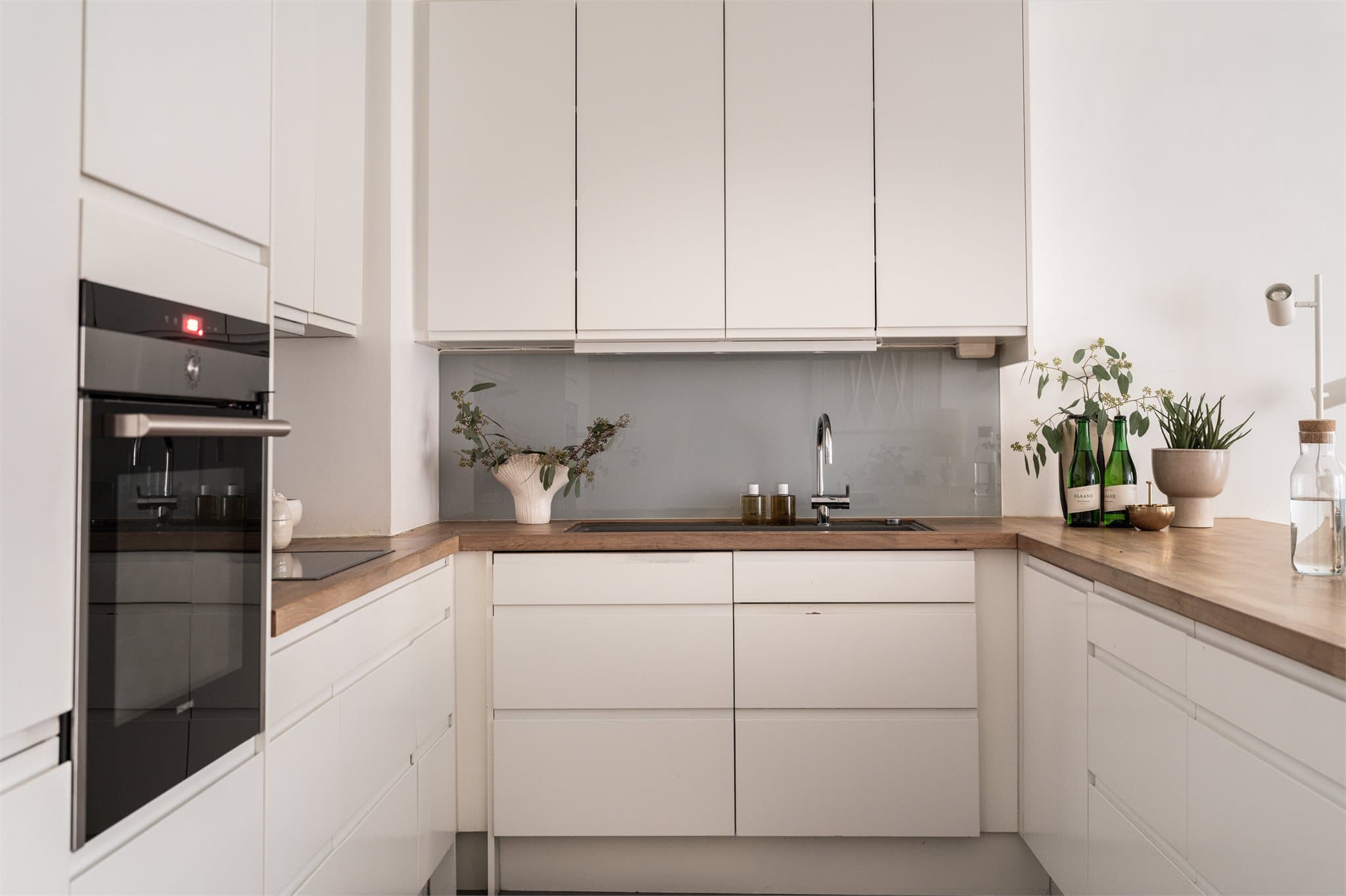 Kjøkkenet har glatte fronter, heltre benkeplate og integrerte hvitevarer som følger med.