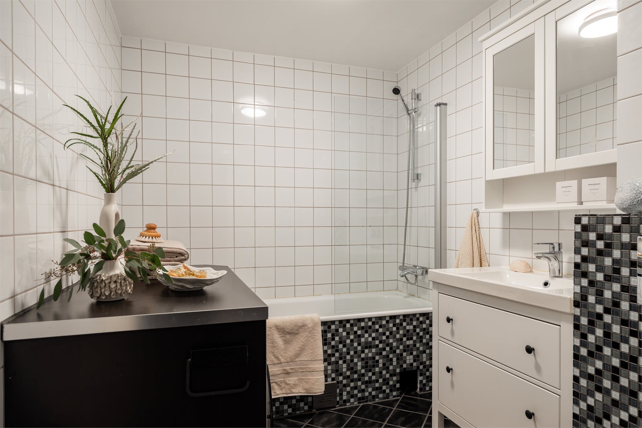 Badet har et særpreget mosaikkuttrykk, og varmekabler i gulvet gir ekstra komfort.